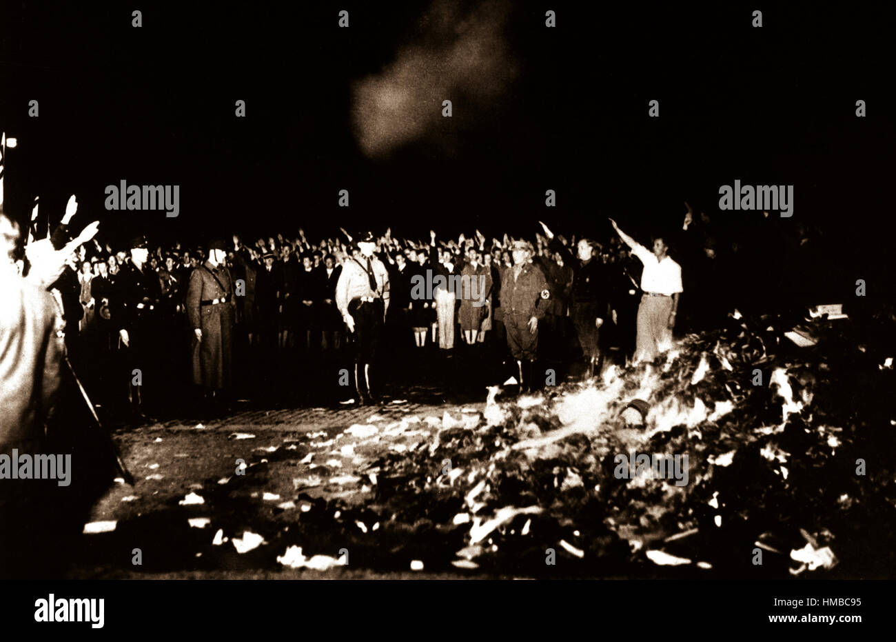 Des milliers de livres dans un énorme feu de couver pendant que les Allemands donner le salut nazi pendant la vague de livres brûlés qui s'est répandu dans toute l'Allemagne. 1933. Banque D'Images