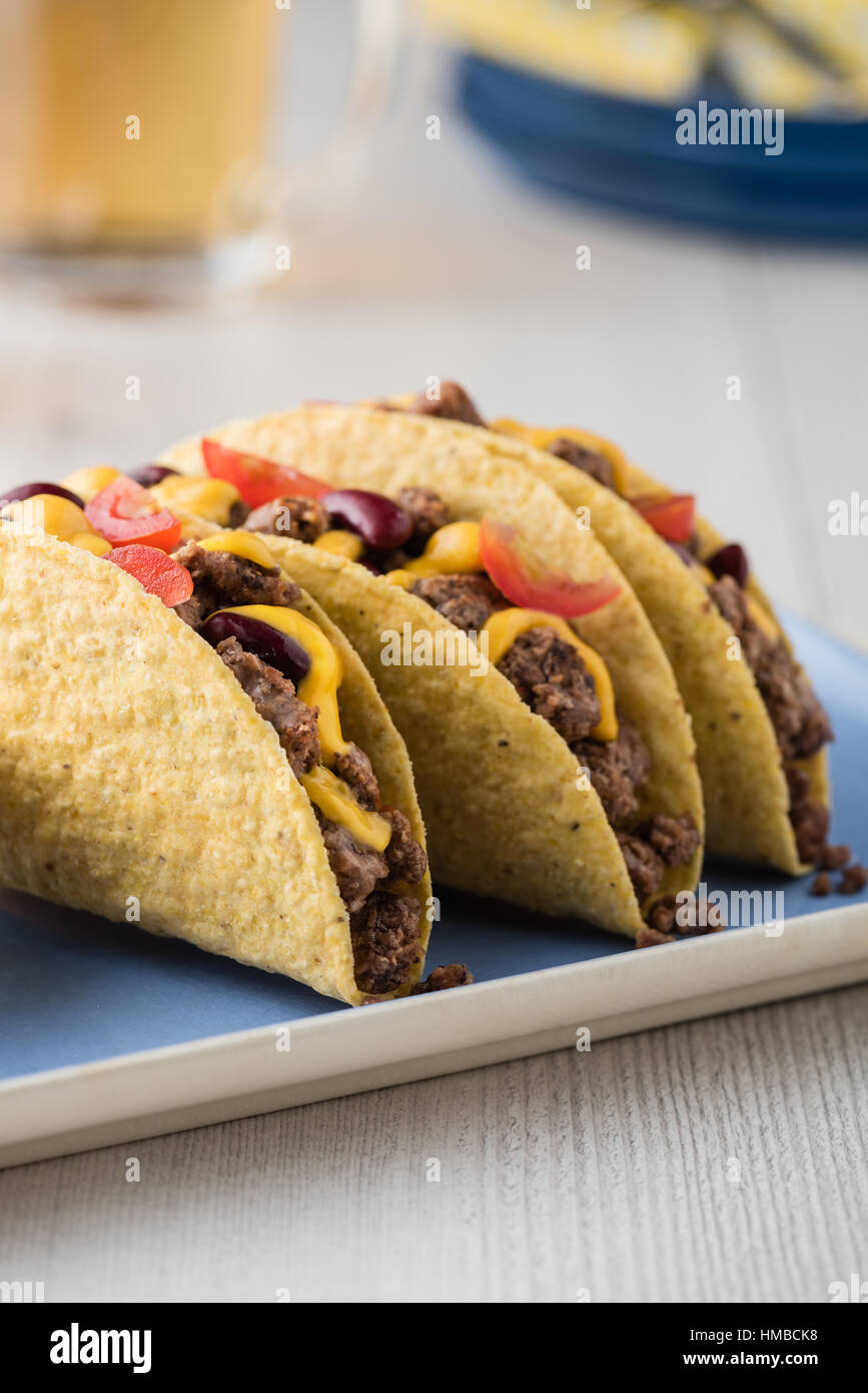 Tacos au boeuf avec la salsa,le fromage cheddar, tomates, haricots et de la bière Banque D'Images