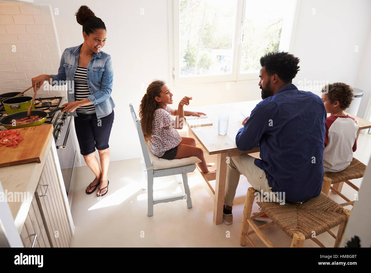 Aider les enfants à faire leurs devoirs papa et maman cuisiniers, elevated view Banque D'Images