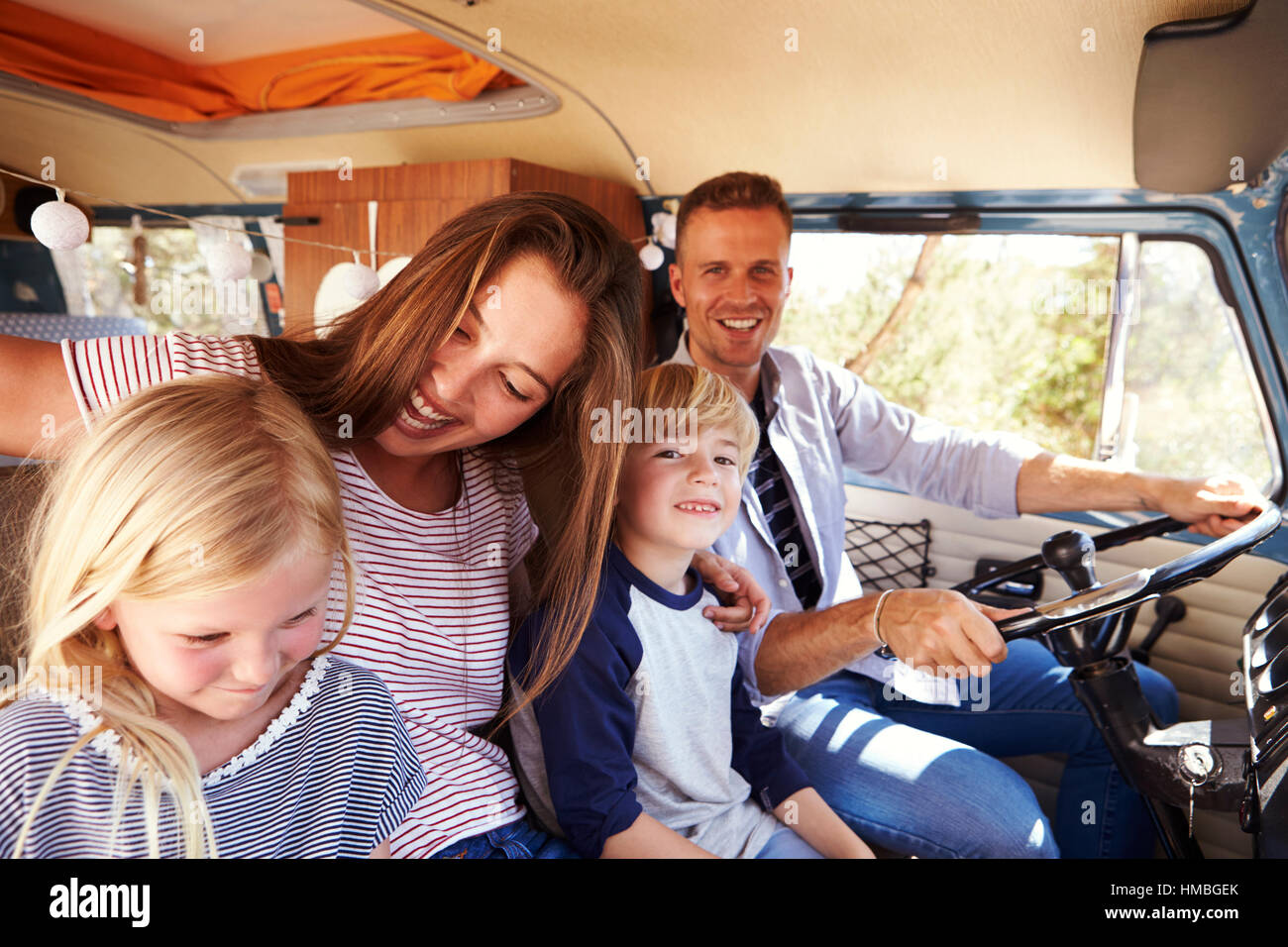 Famille assis à l'avant de leur camping-van, papa au volant Banque D'Images