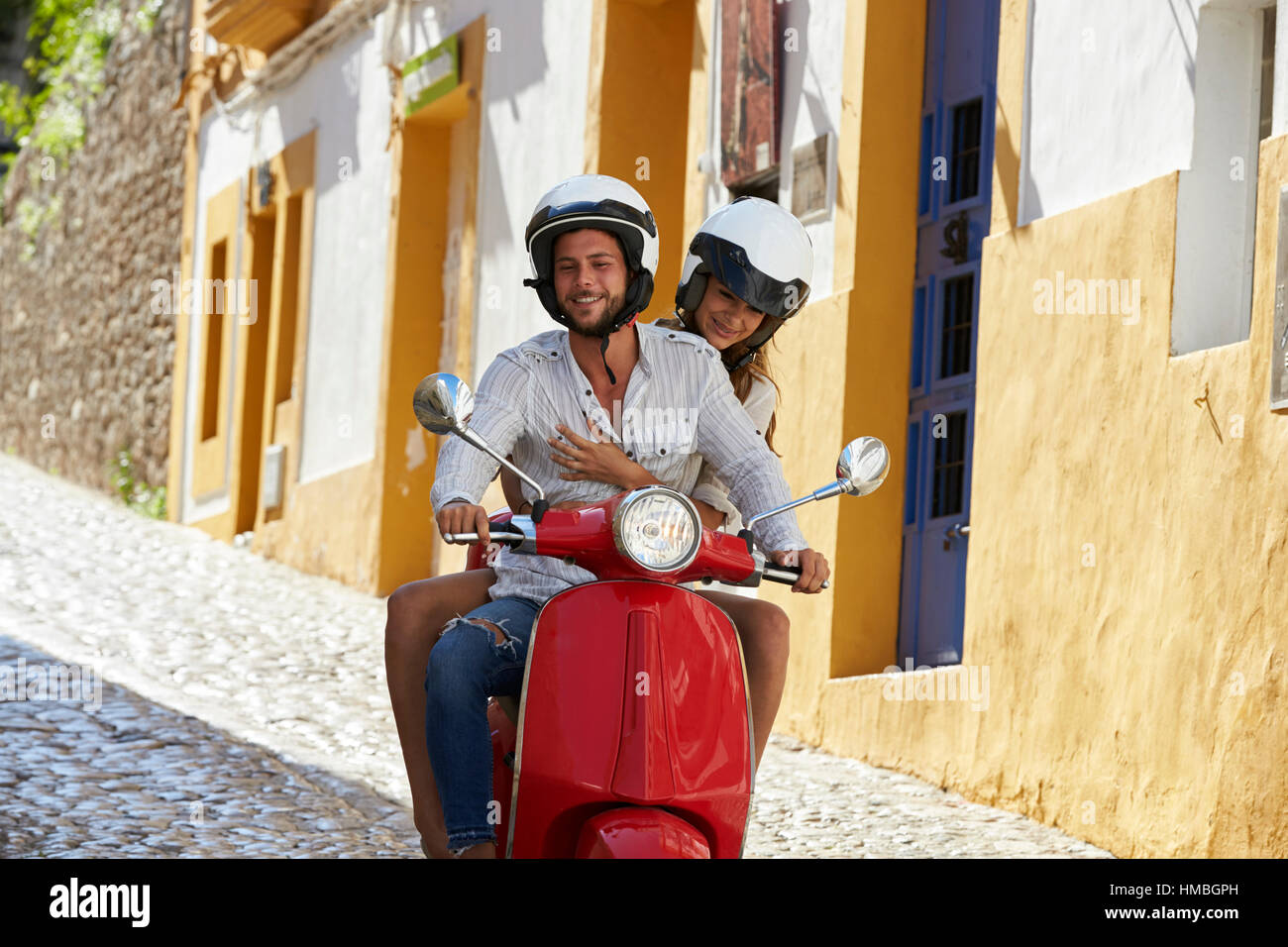 Couple riding scooter dans la vieille rue Ibiza, Close up Banque D'Images