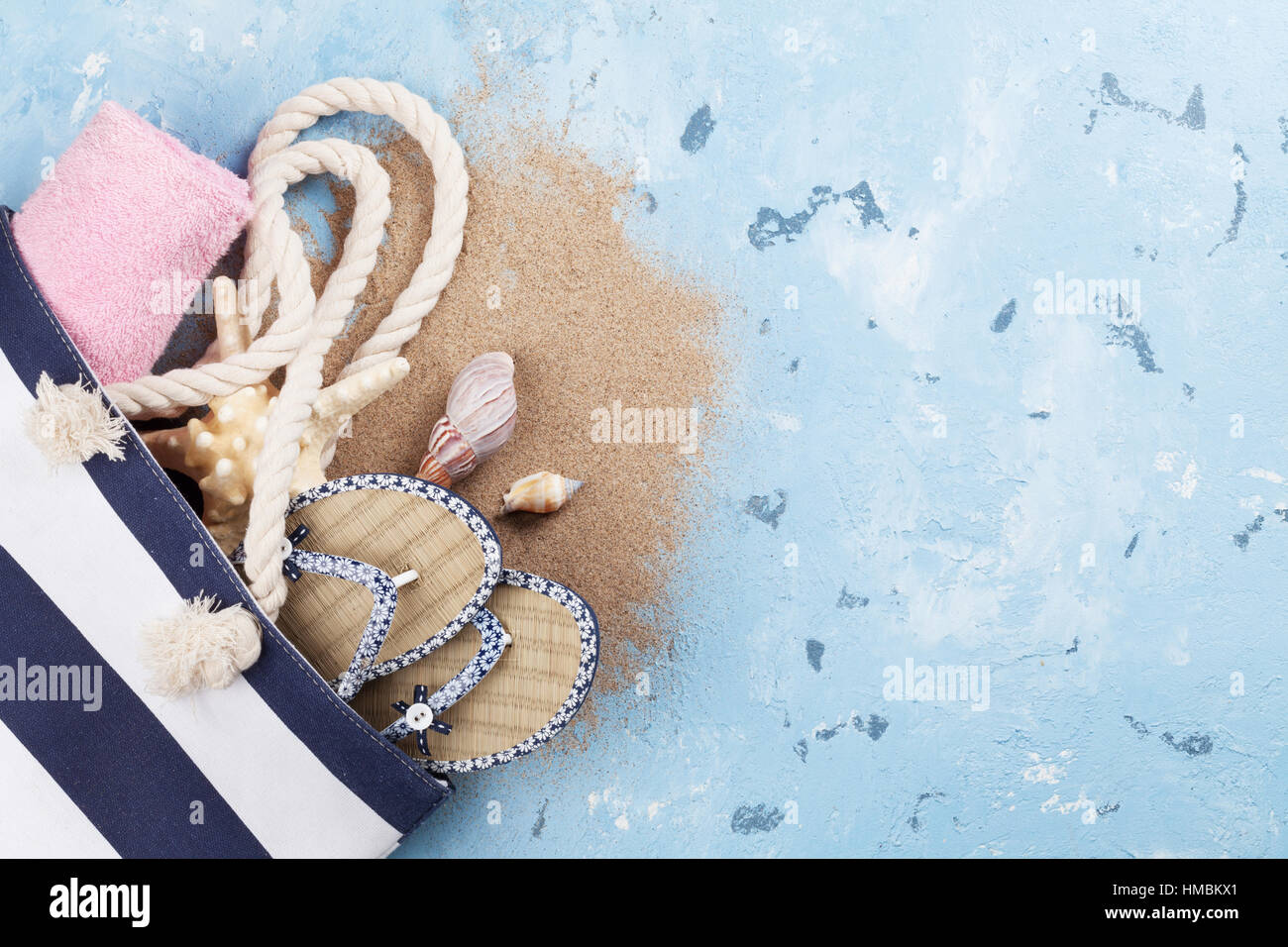 Accessoires de plage. Sac, serviette et tongs sur fond de pierre. Top View with copy space Banque D'Images