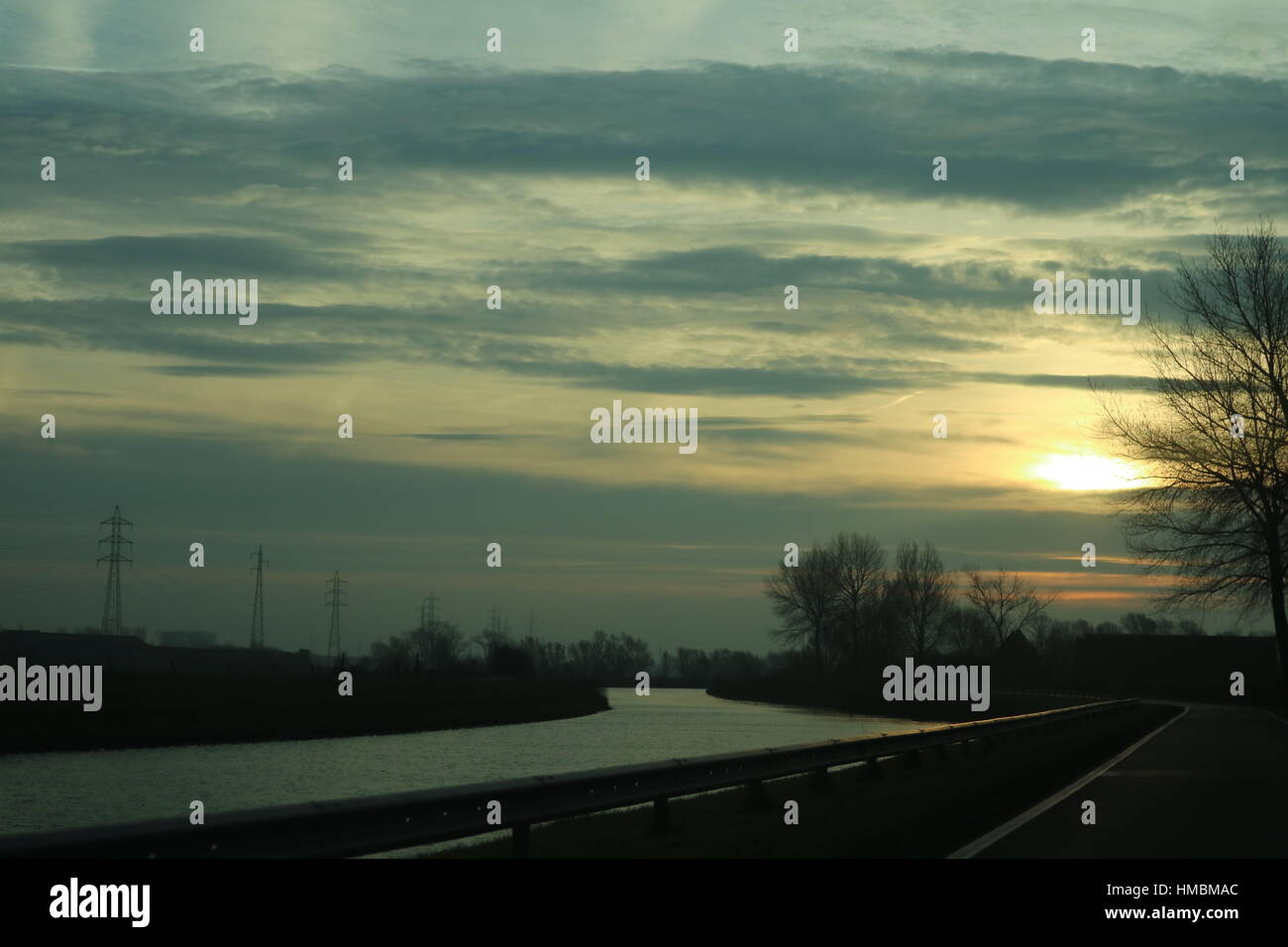 Soleil derrière les nuages reflétant sur l'eau Banque D'Images