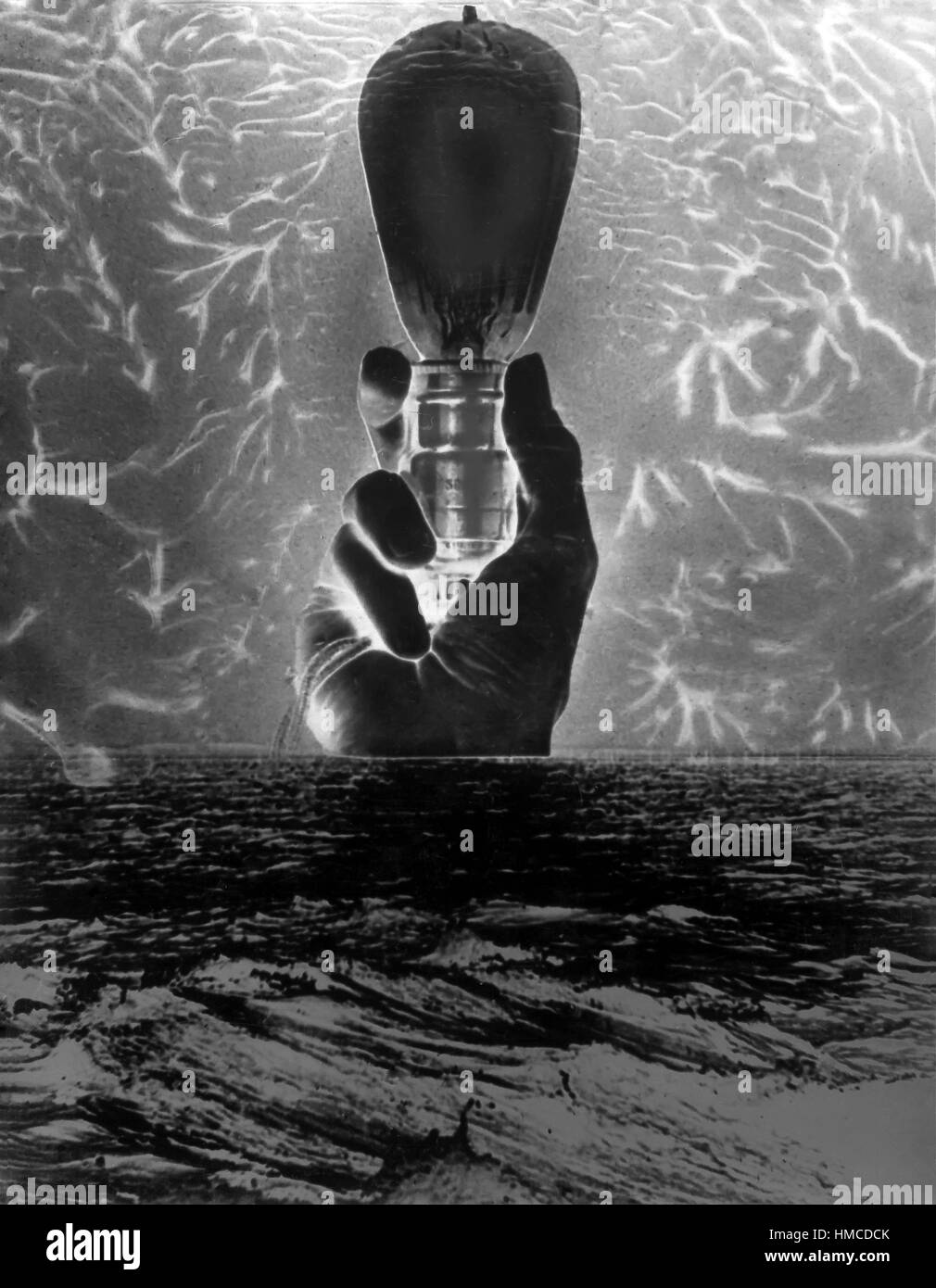 Collage créatif noir et blanc d'une main tenant une ampoule vintage avec les rayons de lumière autour de lui. Banque D'Images