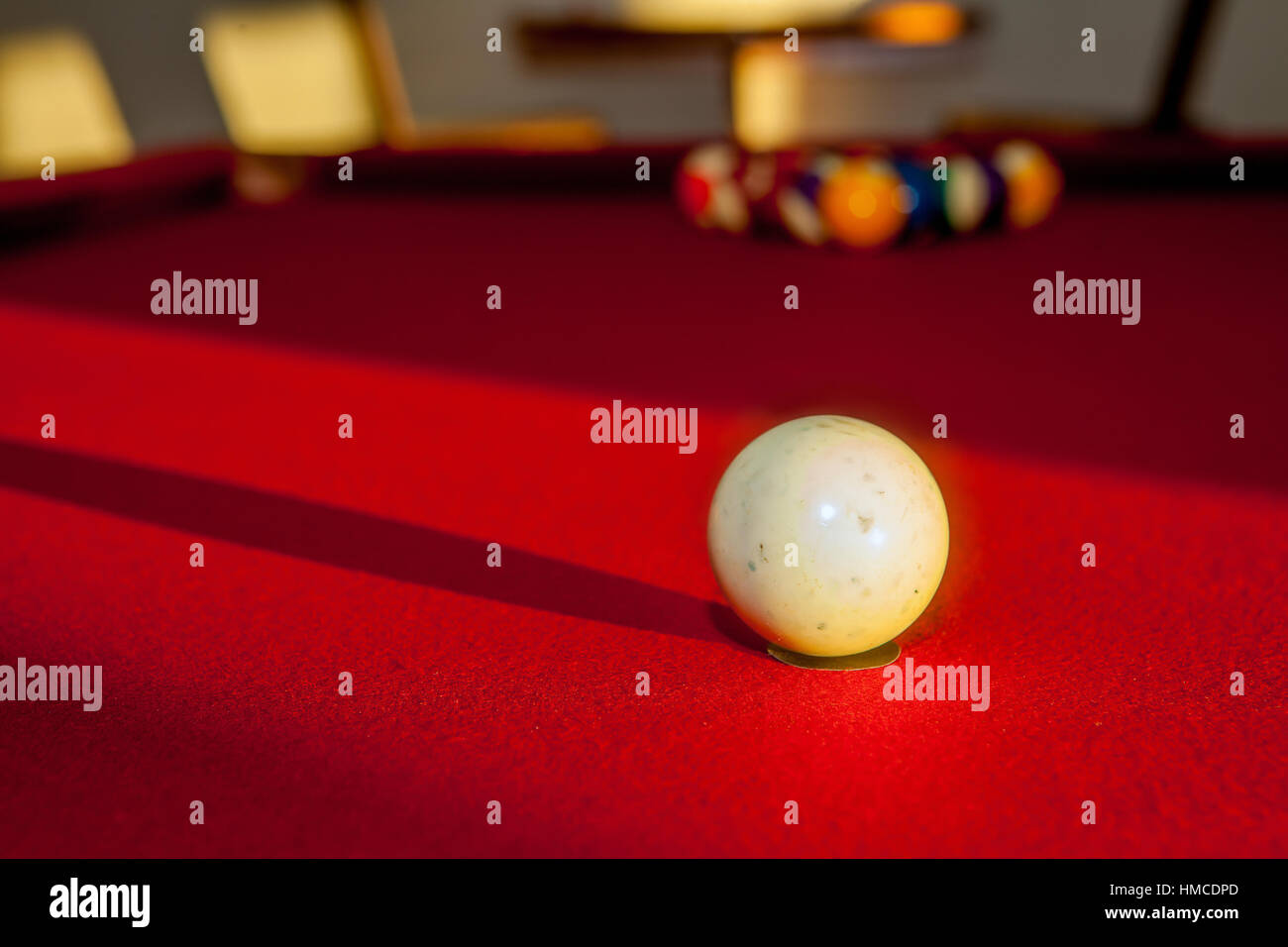 Utilisé blanc et éraflée, boule de choc sur un feutre rouge table de billard. Banque D'Images