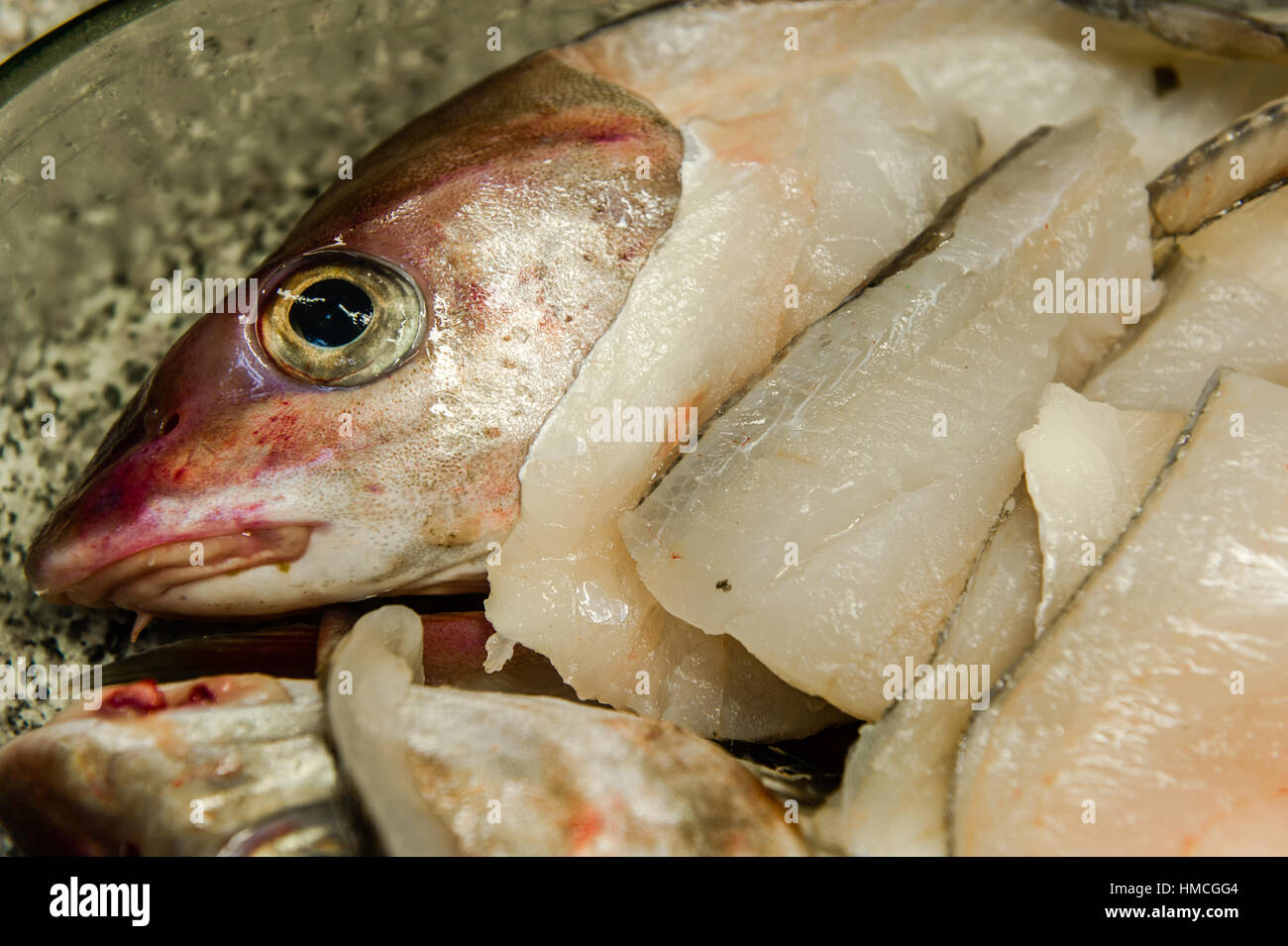 La tête et l'aiglefin filets dans un plat dans une cuisine domestique. Banque D'Images