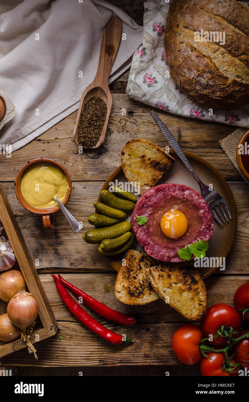 Tartare de boeuf, un plat délicieux plat de protéines avec des épices, de la moutarde, l'oeuf et le pain frit à l'ail Banque D'Images