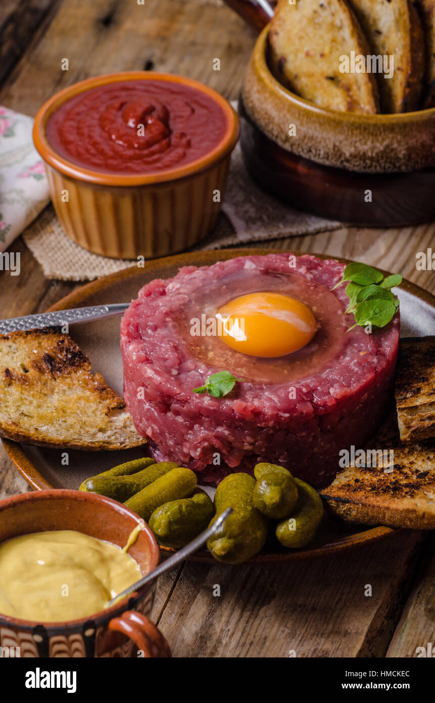 Tartare de boeuf, un plat délicieux plat de protéines avec des épices, de la moutarde, l'oeuf et le pain frit à l'ail Banque D'Images