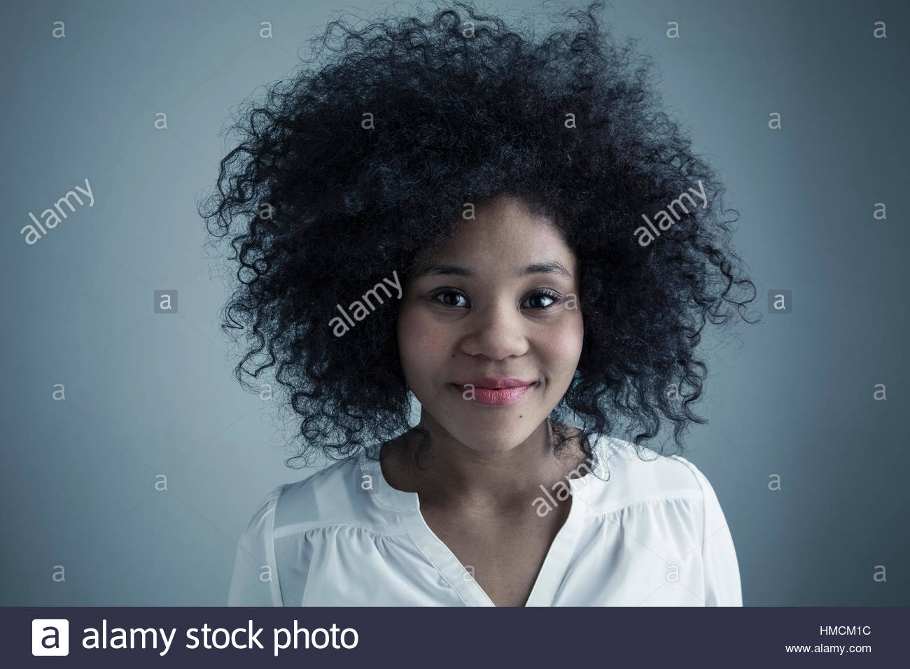 Portrait confiant mixed race jeune femme avec des cheveux noirs bouclés Banque D'Images