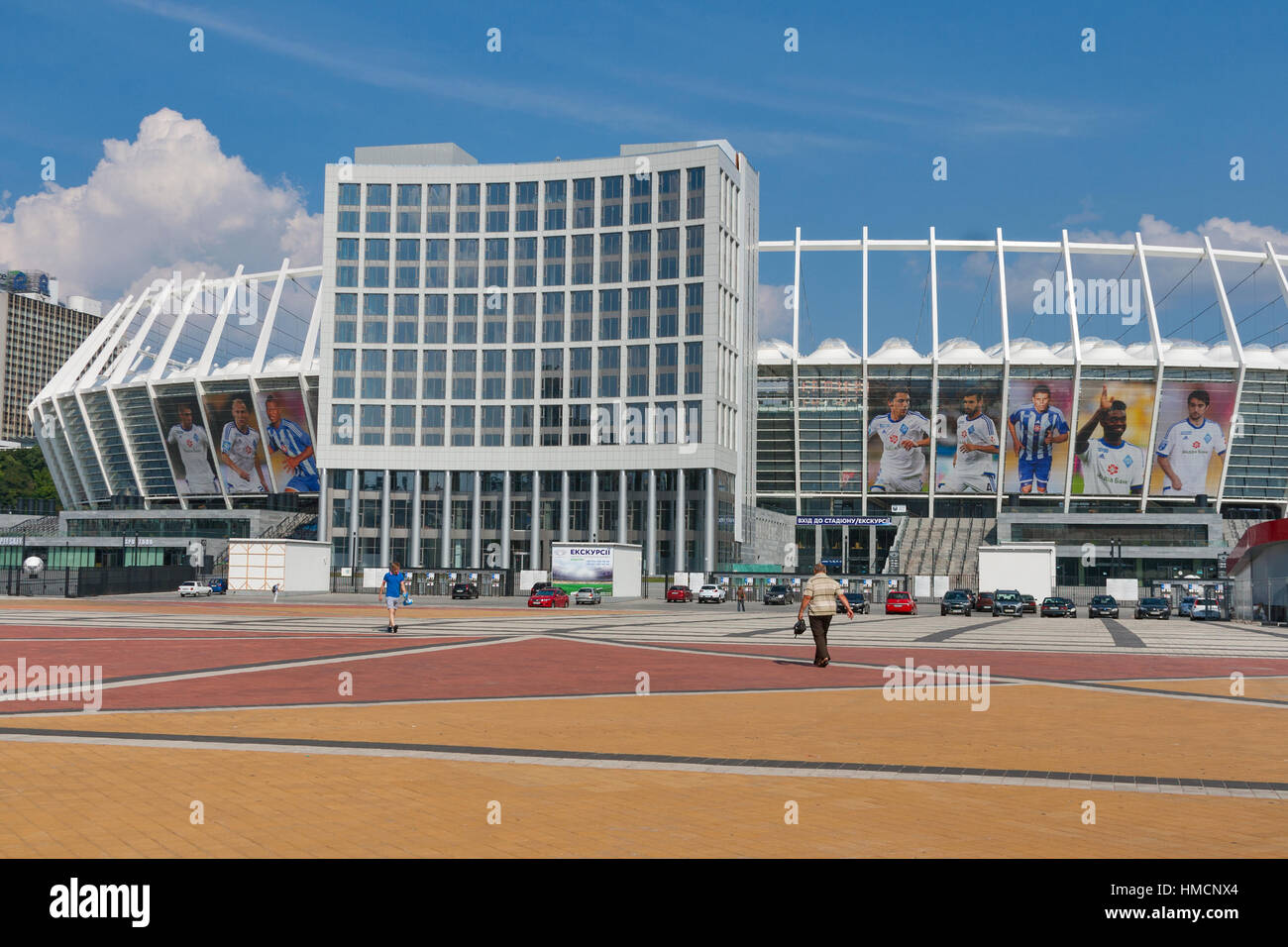 KIEV, UKRAINE - 07 Août : Les gens marchent le long du complexe sportif national Olympique a accueilli la finale de l'Euro 2012 et des bannières avec des portraits de Dynamo Kiev f Banque D'Images