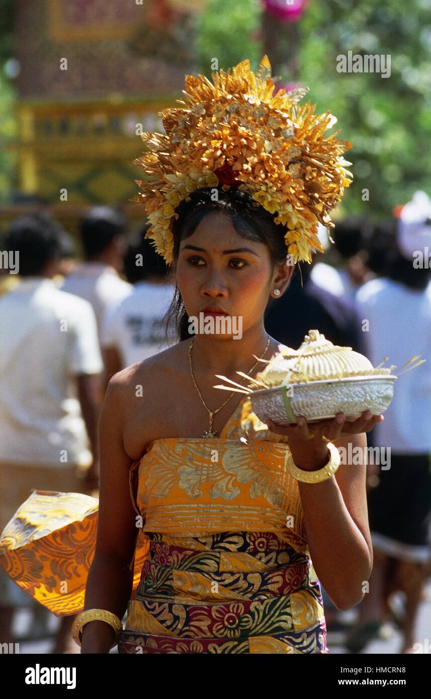 Jeune fille portant un costume traditionnel lors d'une procession religieuse portant une offrande, Bali, Indonésie. Banque D'Images