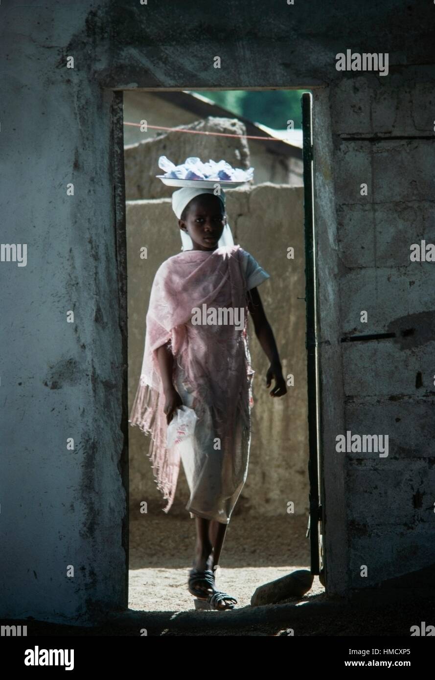 Une jeune fille portant un plateau sur sa tête, Maroua, Cameroun. Banque D'Images