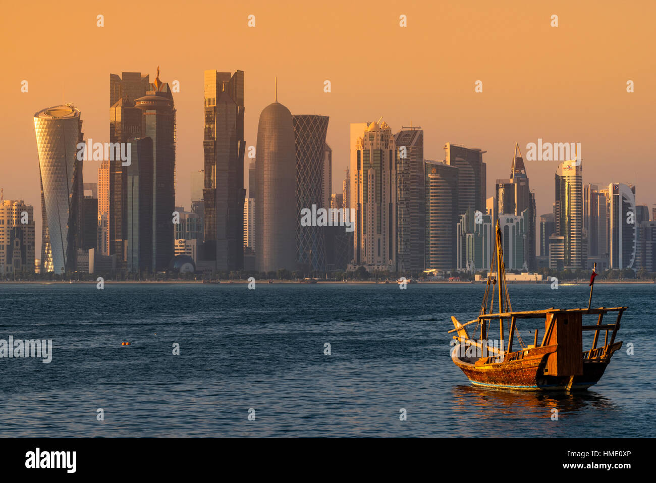 Bateau à voile traditionnel dhow avec le domaine financier derrière l'horizon, Doha, Qatar Banque D'Images