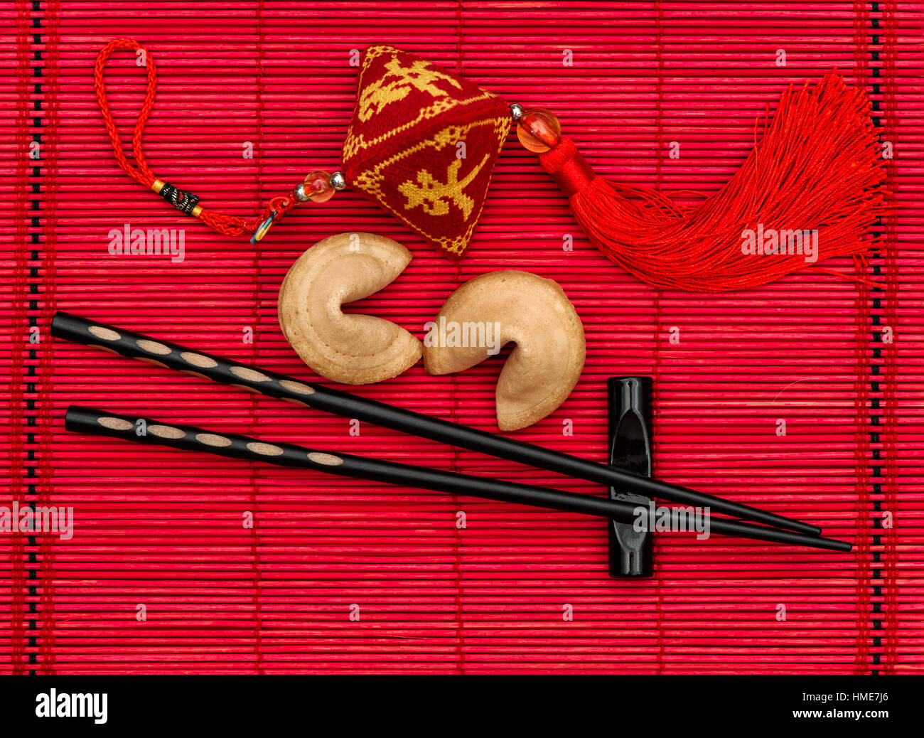 Baguettes en bambou noir sur rouge mat. Table style asiatique place avec le nouvel an chinois l'ornement. Lucky Charm Banque D'Images