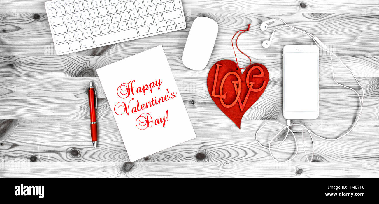 Travail de bureau avec Cœur rouge, téléphone, casque, clavier, papeterie et fournitures de bureau. Décoration Saint Valentin Banque D'Images