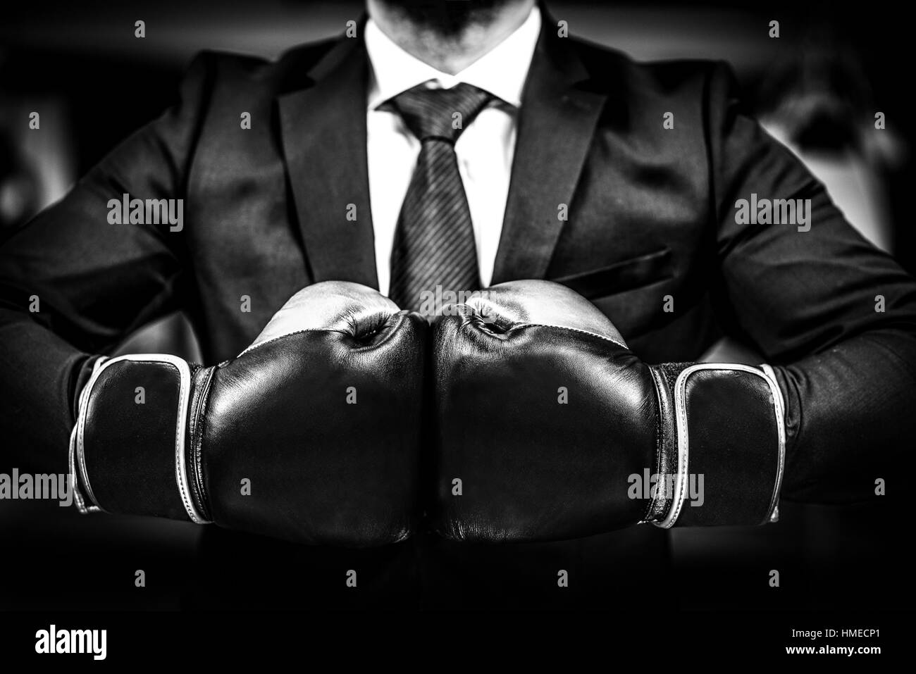 Businessman avec des gants de boxe est prêt pour la bataille. L'homme en costume, chemise et cravate gants de combat est maintenant ensemble. Tourné dans un club de boxe, co Banque D'Images
