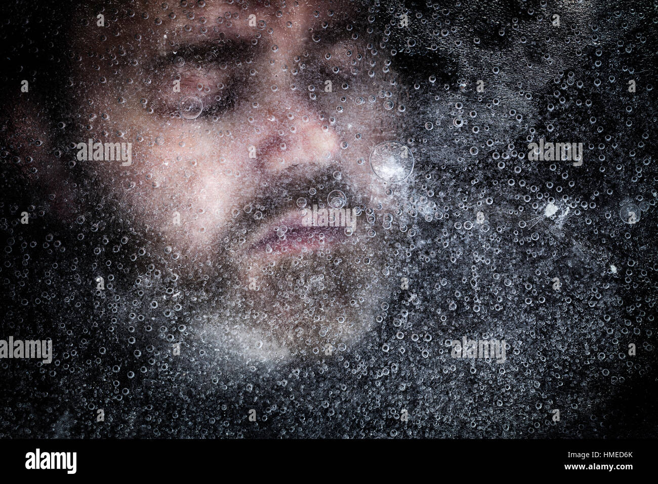 Dead Man sous glace sous un lac gelé. Les yeux fermés avec hyporthermia sur fond sombre Banque D'Images