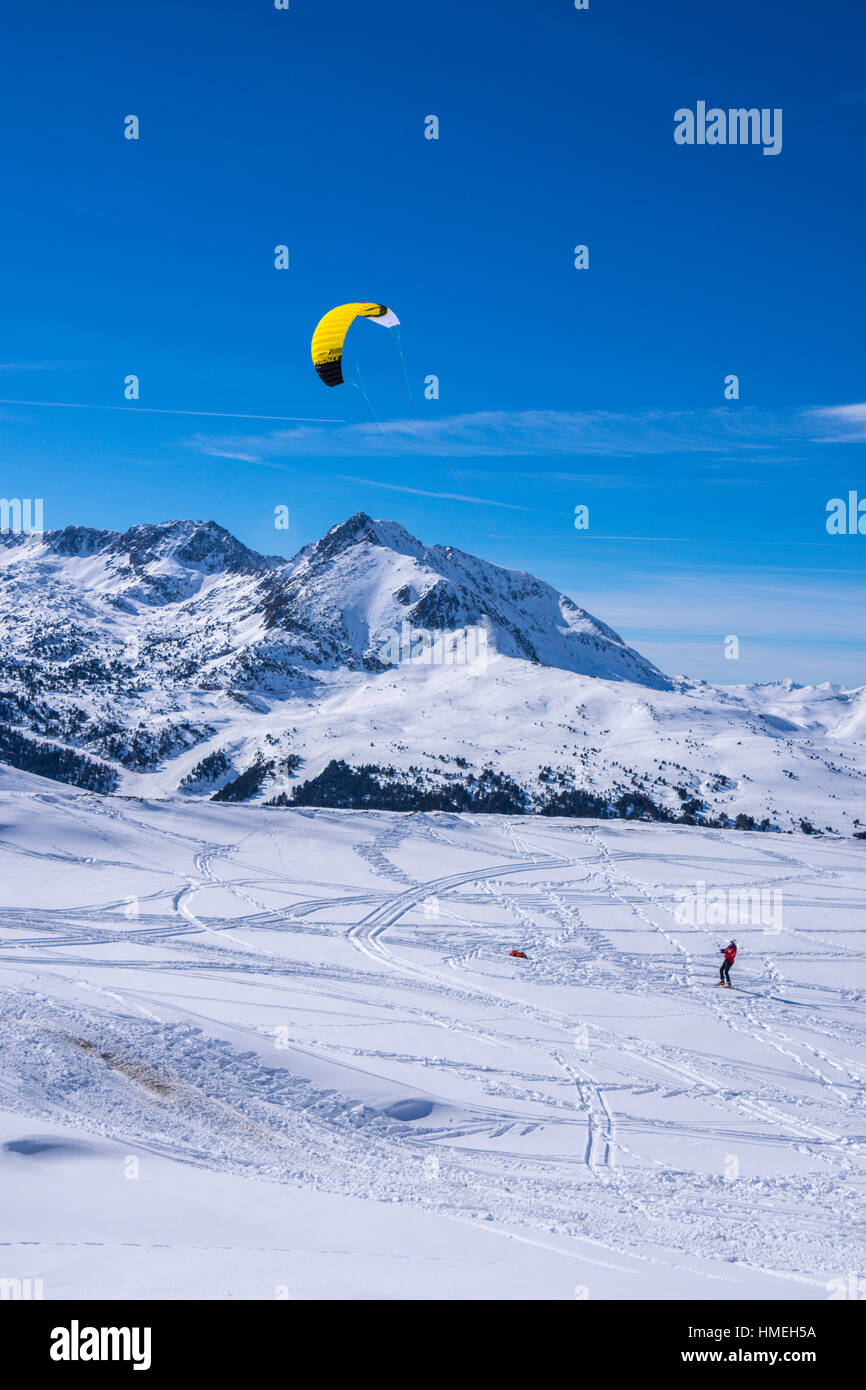 Femme en rouge avec des skieurs de ski cerf-volant jaune Banque D'Images