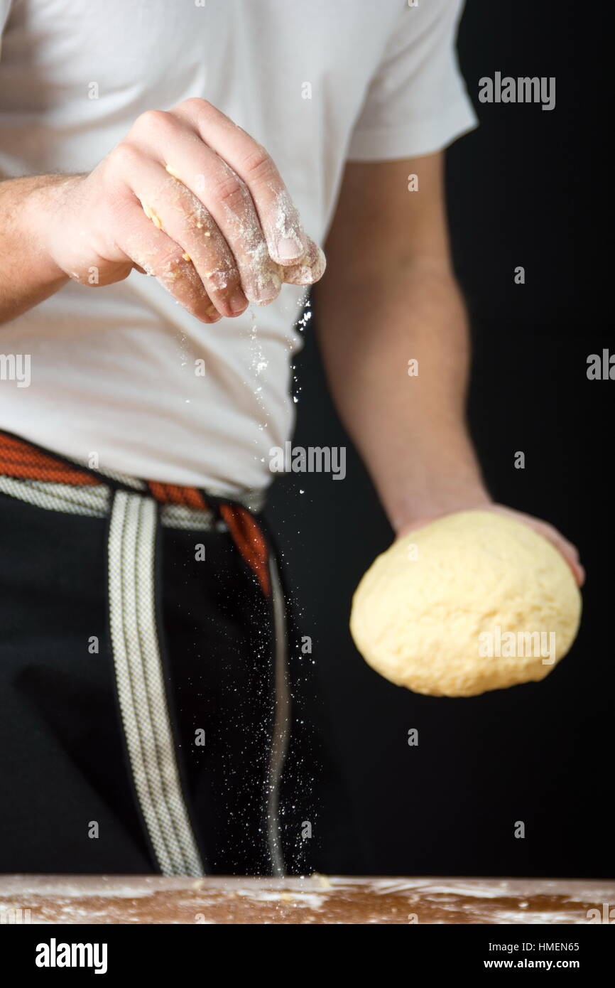 Homme baker holding pâte de farine et de pain tout en Banque D'Images