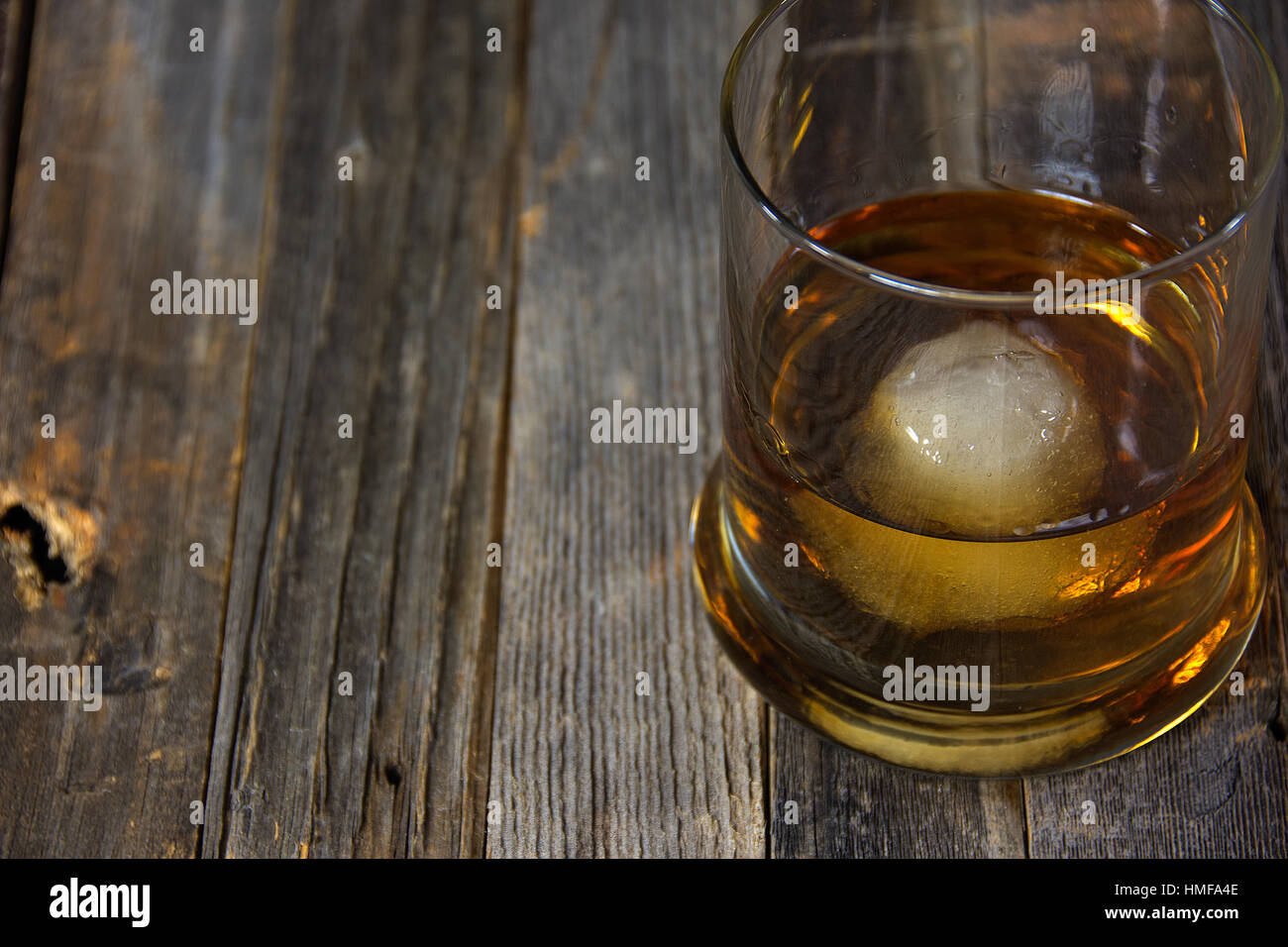 Verre de whisky avec boule de glace en verre sur bois rustique Banque D'Images