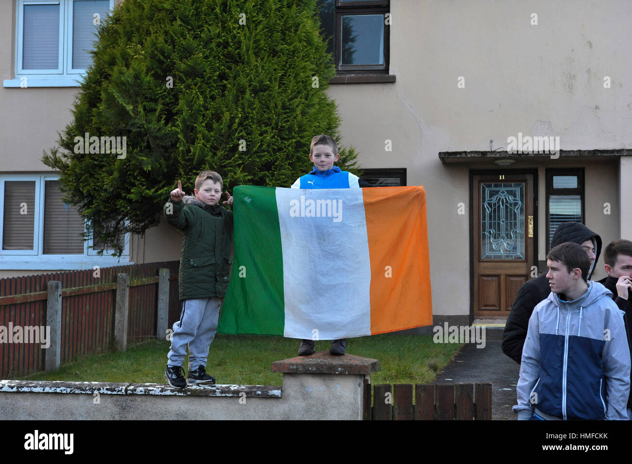 Les enfants tenant un drapeau tricolore irlandais au cours de la succession dans le Creggan 45e Marche annuelle le dimanche sanglant de la Justice à Derry, Londonderry. Banque D'Images