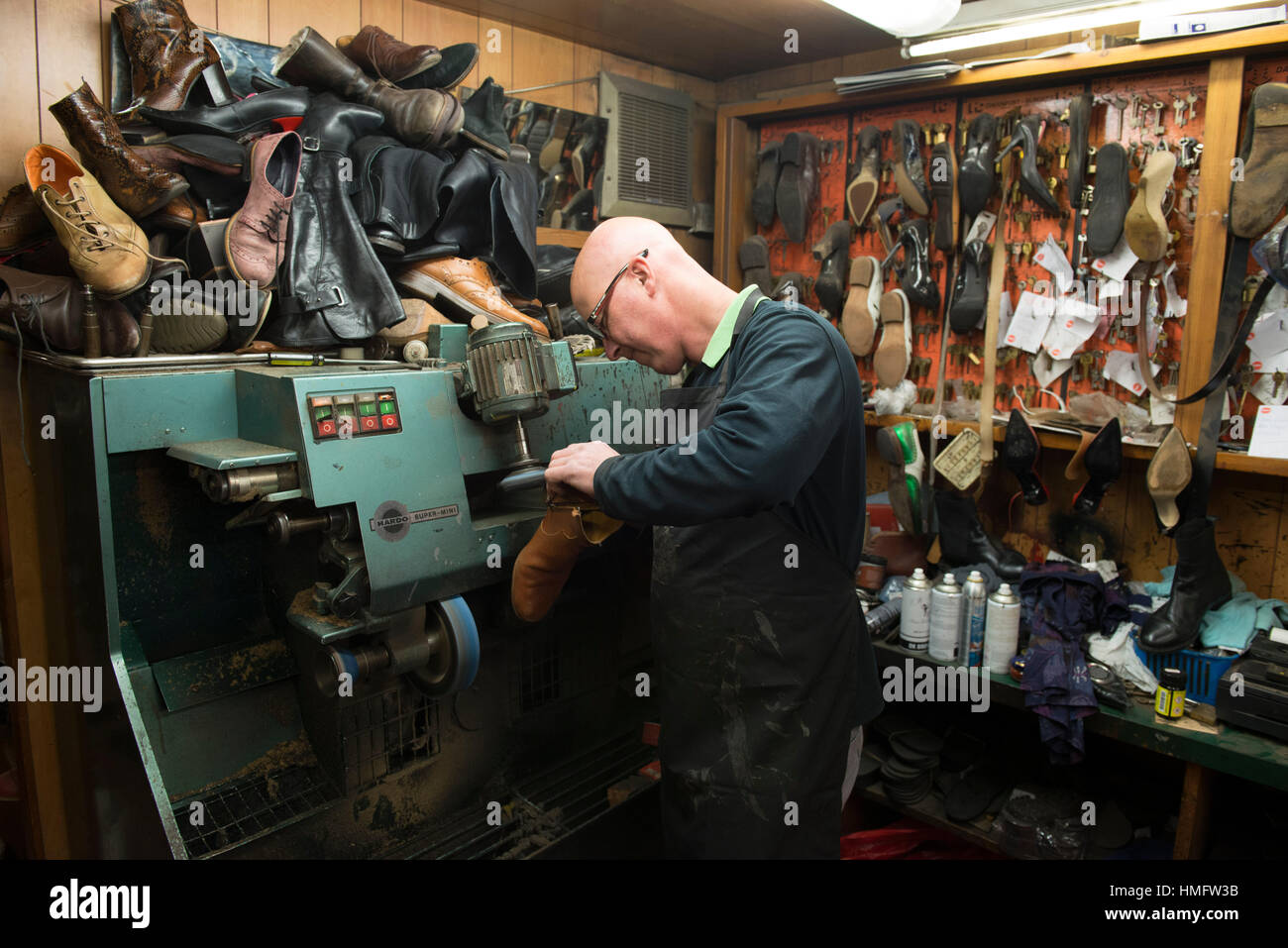 Une ancienne cordonnerie / cordonnier Chaussures fixe dans son atelier à l'aide des techniques traditionnelles et des outils Banque D'Images
