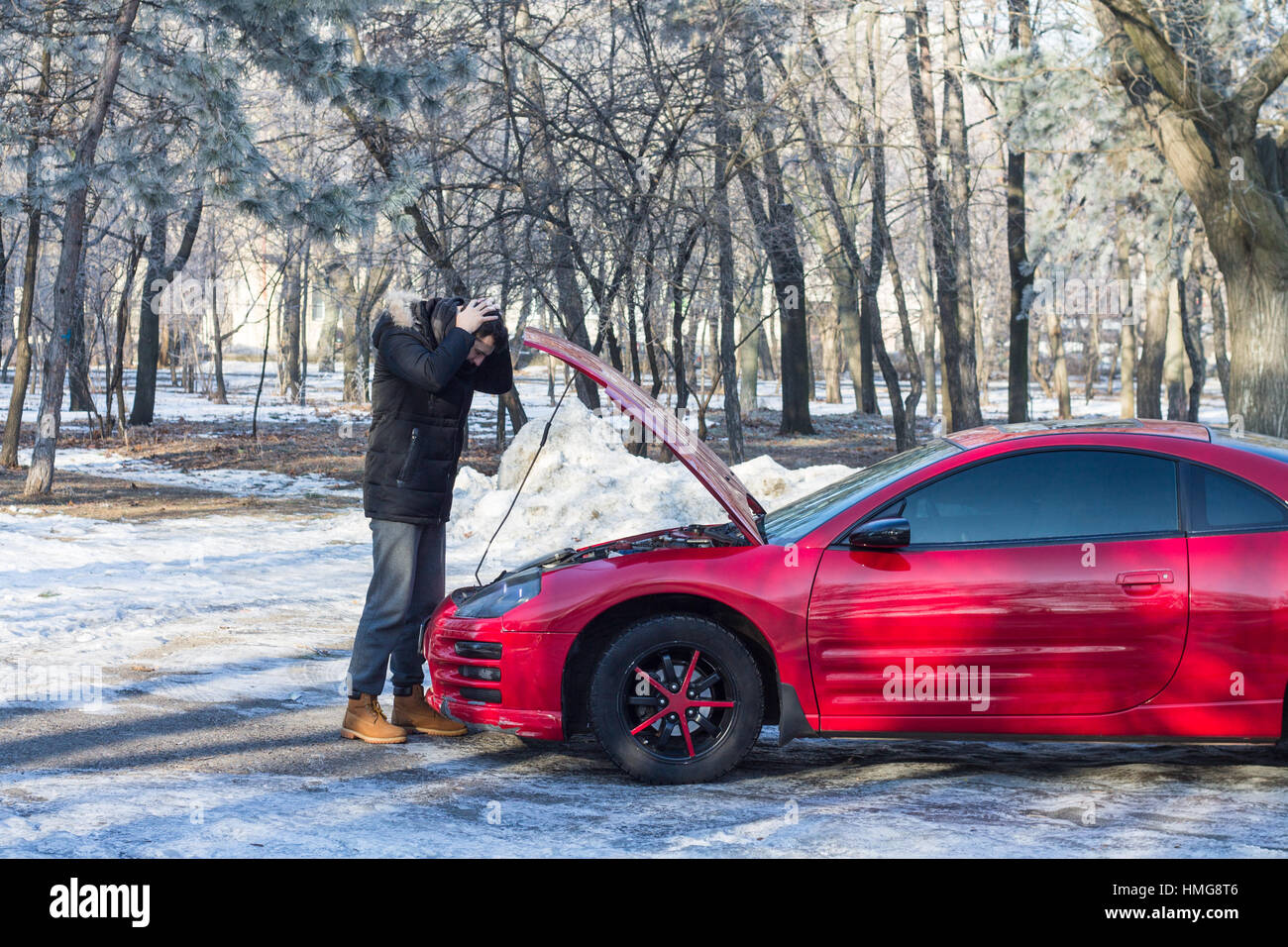 L'homme en difficulté avec sa voiture sport .Il est inquiet, il a les mains sur sa tête. Geste émotif Banque D'Images