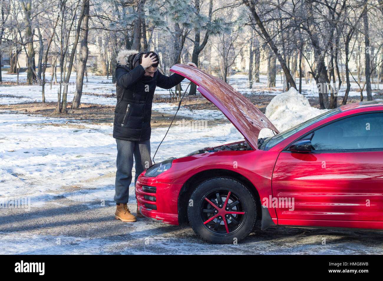 L'homme en difficulté avec sa voiture sport .Il est inquiet, il a les mains sur sa tête. Geste émotif Banque D'Images