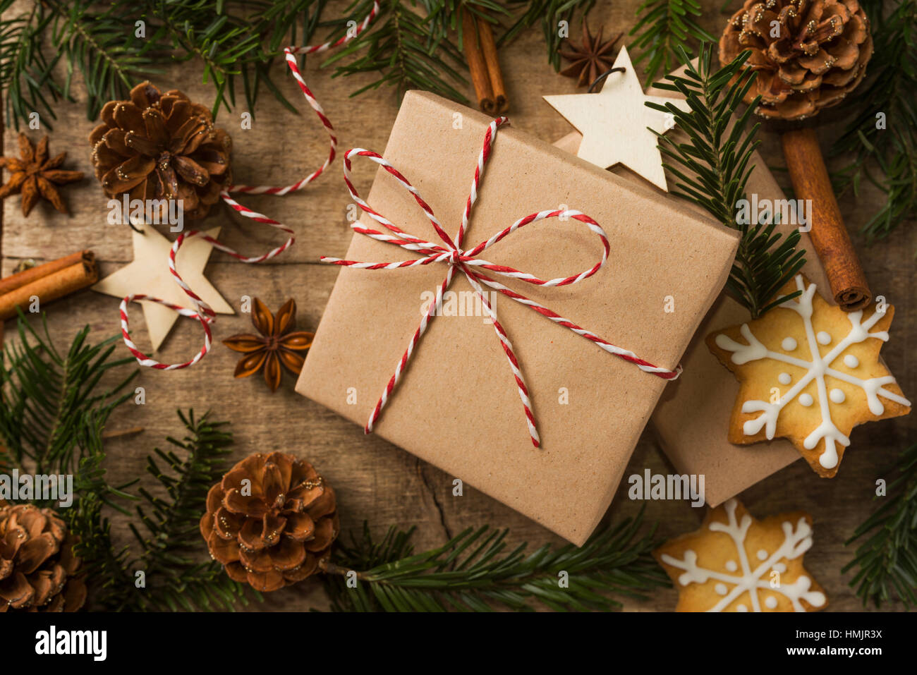 Cadeau de Noël enveloppé dans du papier kraft et entouré de décoration. Photo tonique pour des couleurs chaudes Banque D'Images