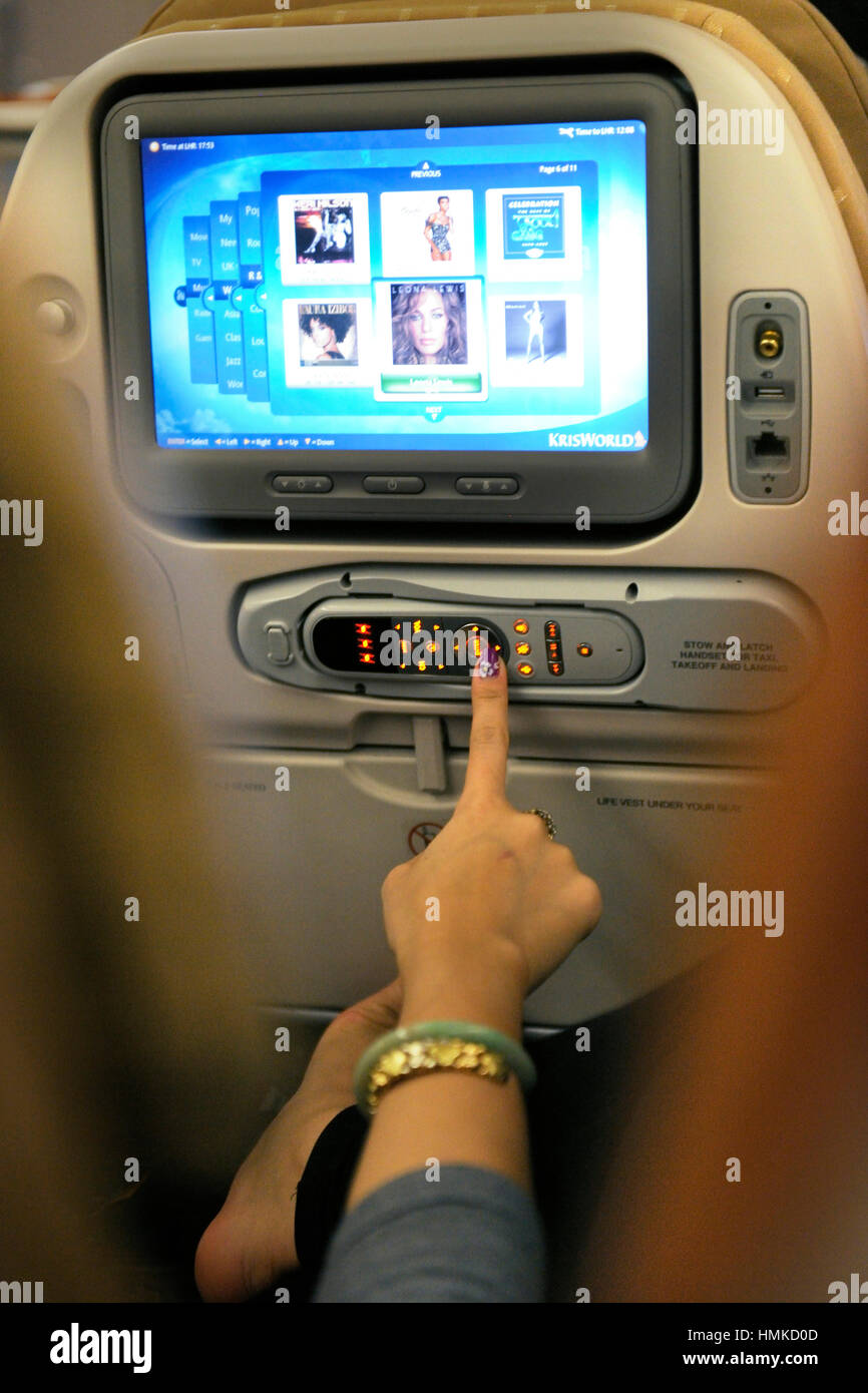 Femme sélection de musique sur divertissement à bord en cabine de classe économique SIA Singapore Airlines Airbus A380-800 enroute SIN-LHR Banque D'Images