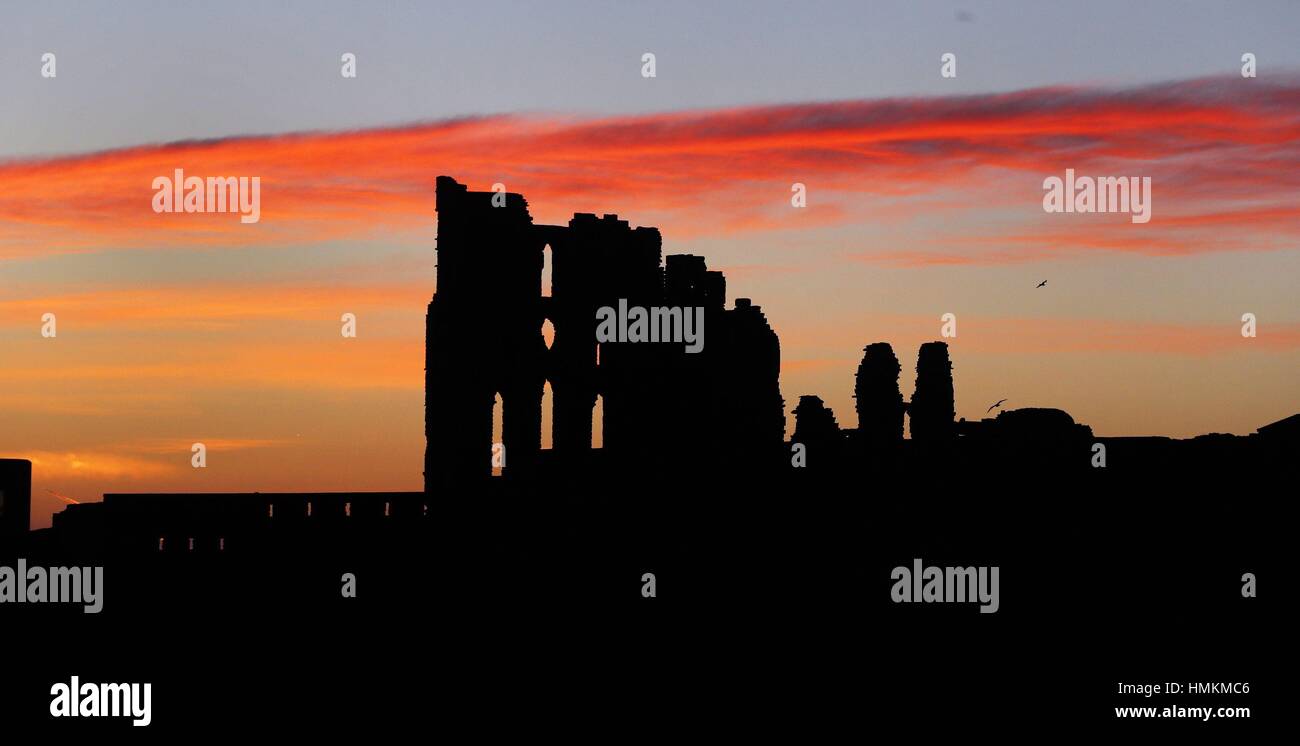 Le soleil se lève sur Tynemouth Priory sur la sur la côte nord-est, comme le week-end des températures devrait s'écrouler comme temps incertain semble prêt à diviser le pays. Banque D'Images