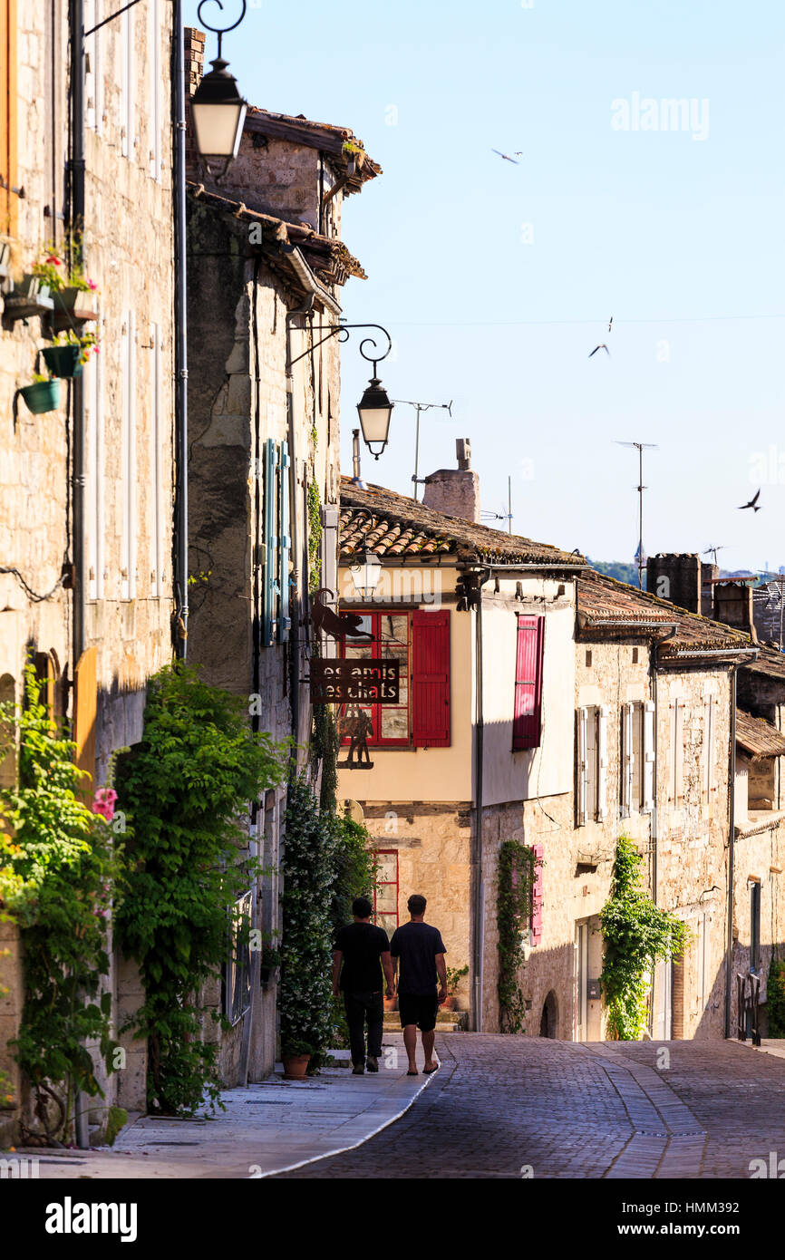 Couple walking down rue étroite à Lauzerte, Tarn et Garonne, France Banque D'Images