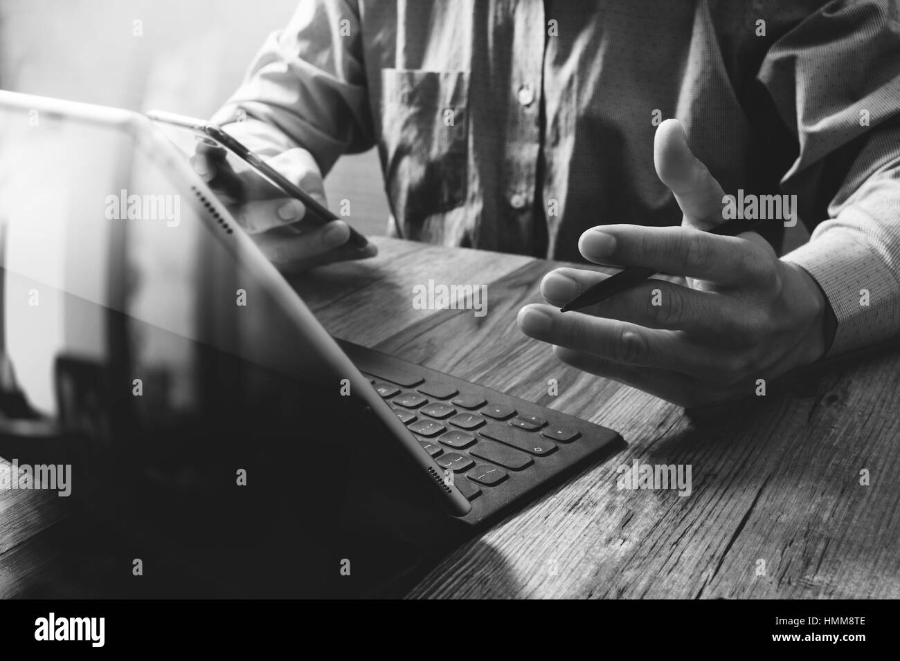 La main à l'aide d'affaires succès stylet pour tablette numérique,smart station d'un clavier sur un bureau en bois blanc, noir Banque D'Images