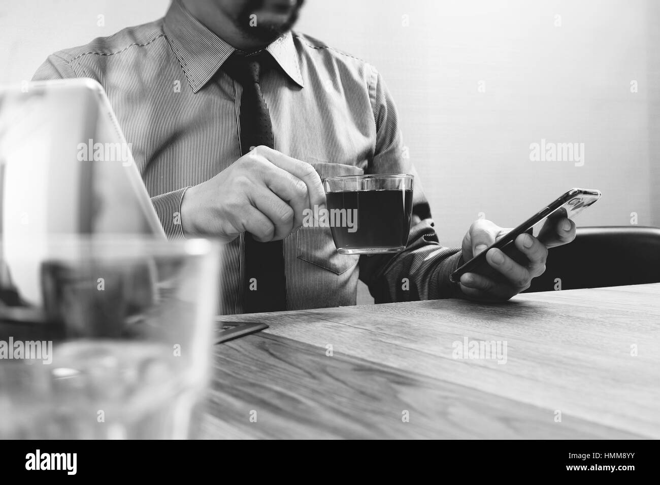 Succès d'affaires part à l'aide de Smart Phone, tablette numérique, clavier intelligent d' sur la tasse de café,bureau en bois noir blanc Banque D'Images