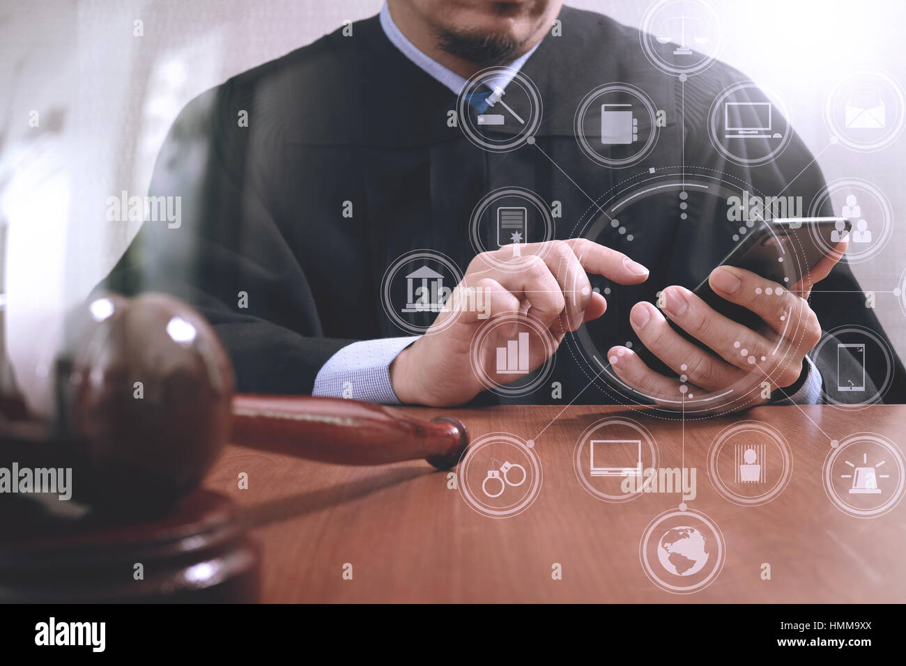 La justice et du droit concept.Homme juge dans une salle d'audience avec le marteau,travailler avec smart phone Ordinateur sur table en bois,les icônes graphiques d'interface virtuelle diagr Banque D'Images