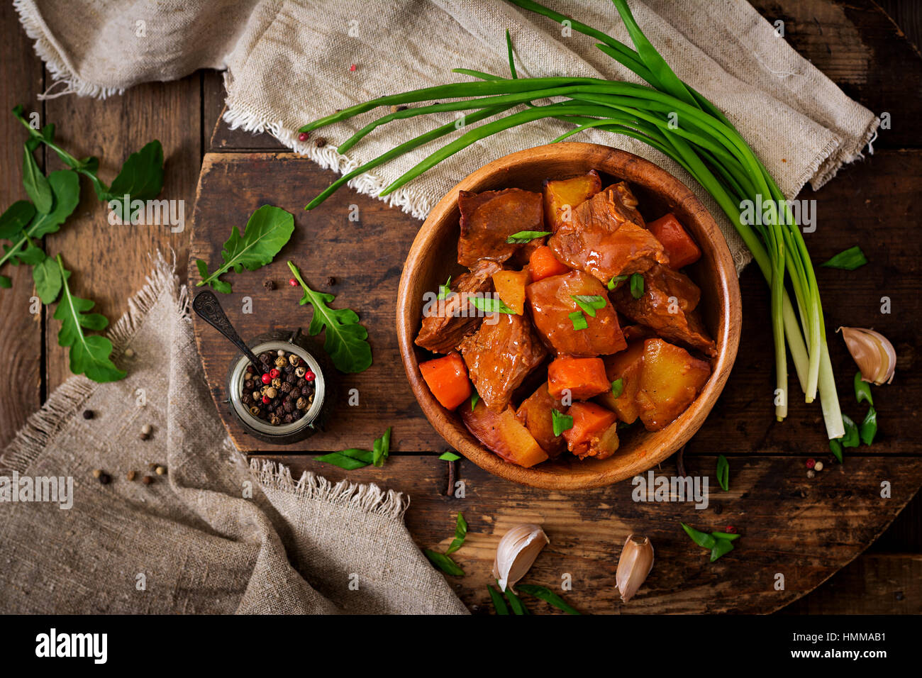 Pomme de terre au four avec du bœuf Bourguignon sur l'ancien fond de bois dans un style rustique. Mise à plat. Vue d'en haut Banque D'Images