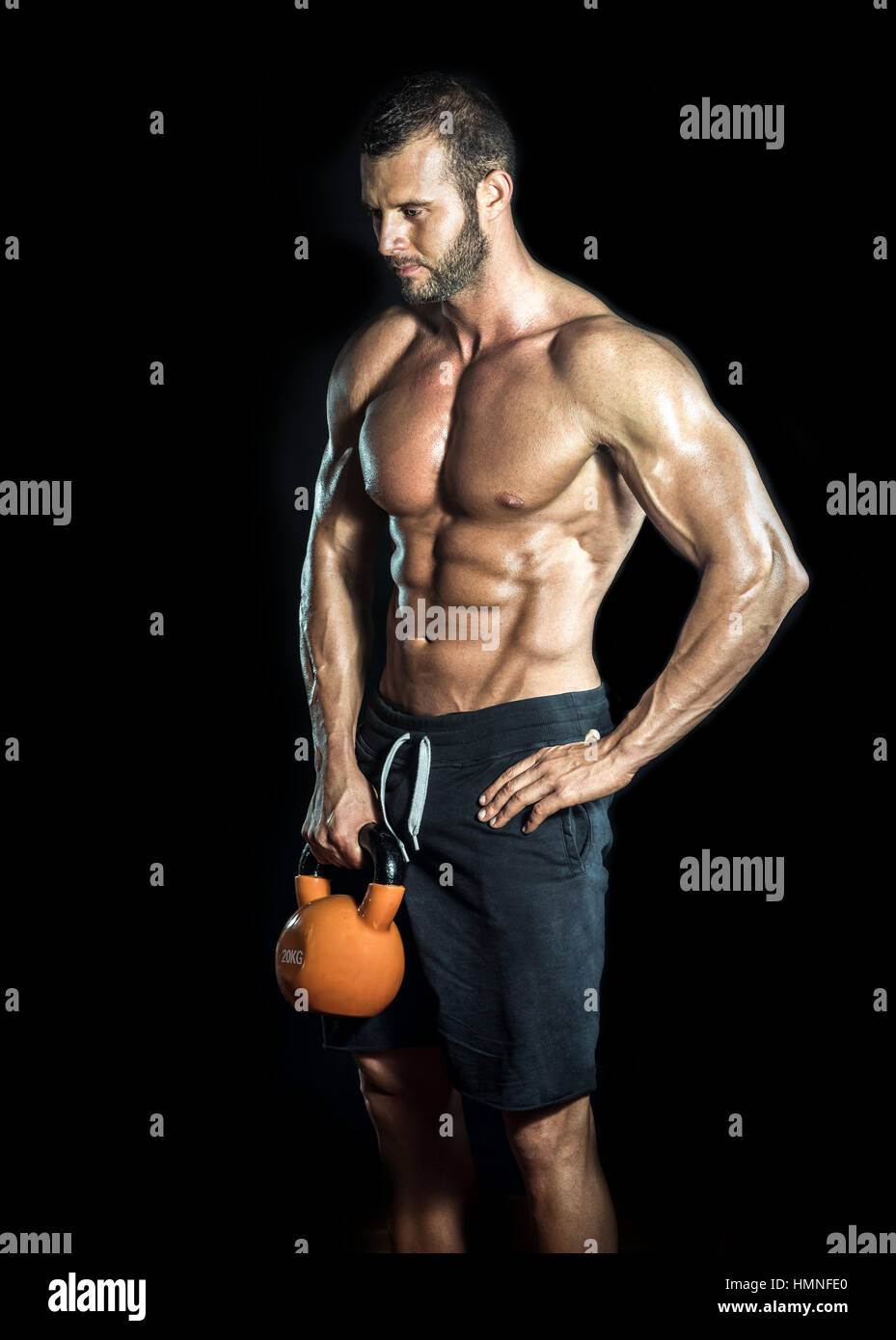 Bodybuilder beau standing avec kettlebell dans les mains. Isolées. Banque D'Images