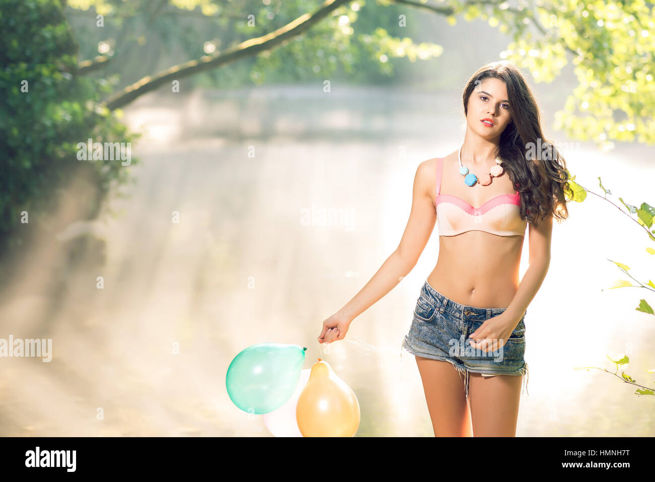 Ados Jeunes adultes jeune fille avec des ballons sur les bords de la rivière dans la matinée de printemps. La tonalité de l'image. Banque D'Images