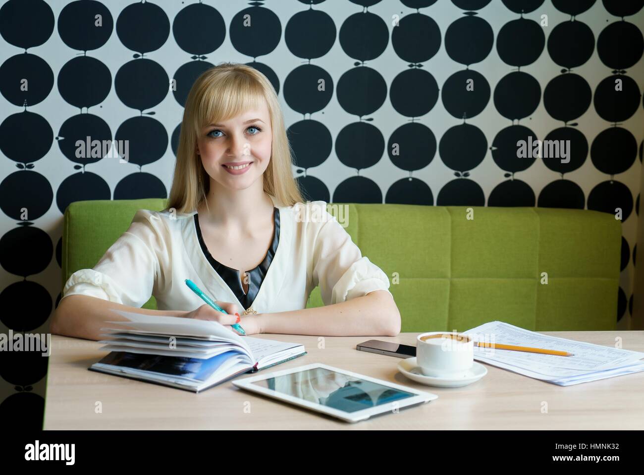 Fille de sms sms à l'aide de mobile phone in cafe Banque D'Images