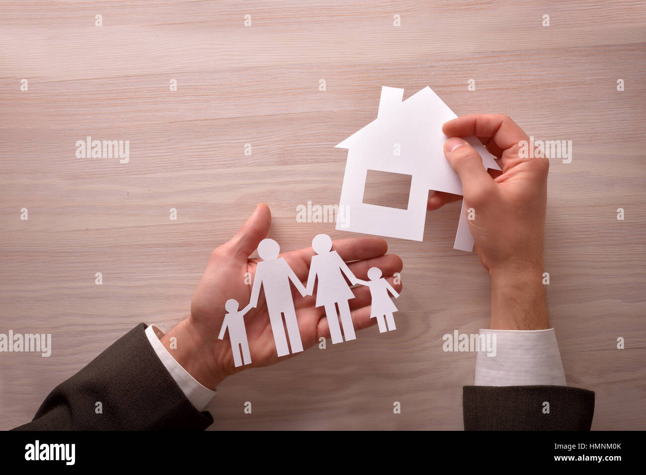 Agent commercial Concept du logement et de la famille avec des découpes dans les mains sur la table en bois brun. Composition horizontale. Vue d'en haut. Banque D'Images