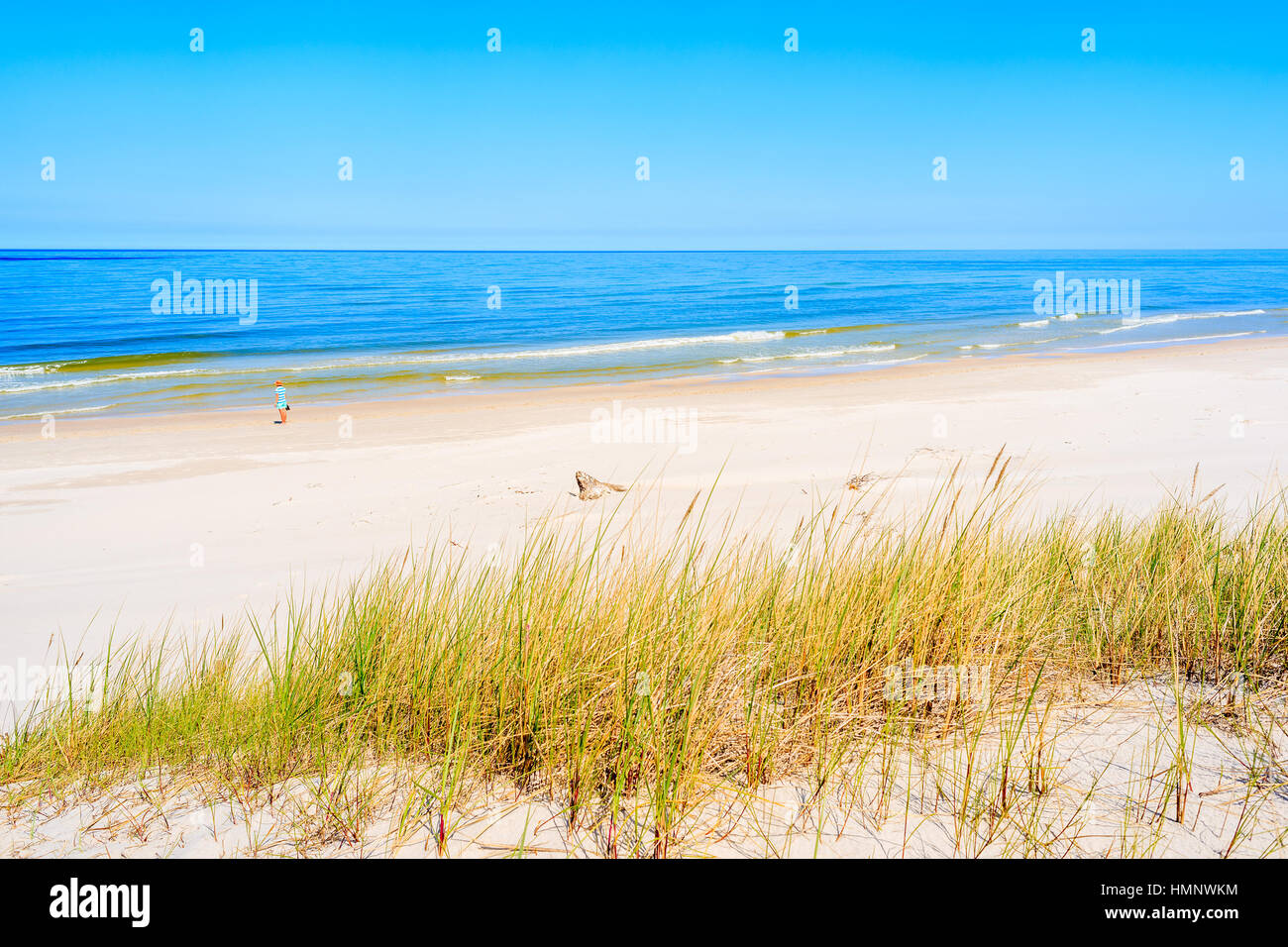 Dunes de sable et d'herbe jeune femme balades touristiques à distance sur Lubiatowo plage, mer Baltique, Pologne Banque D'Images
