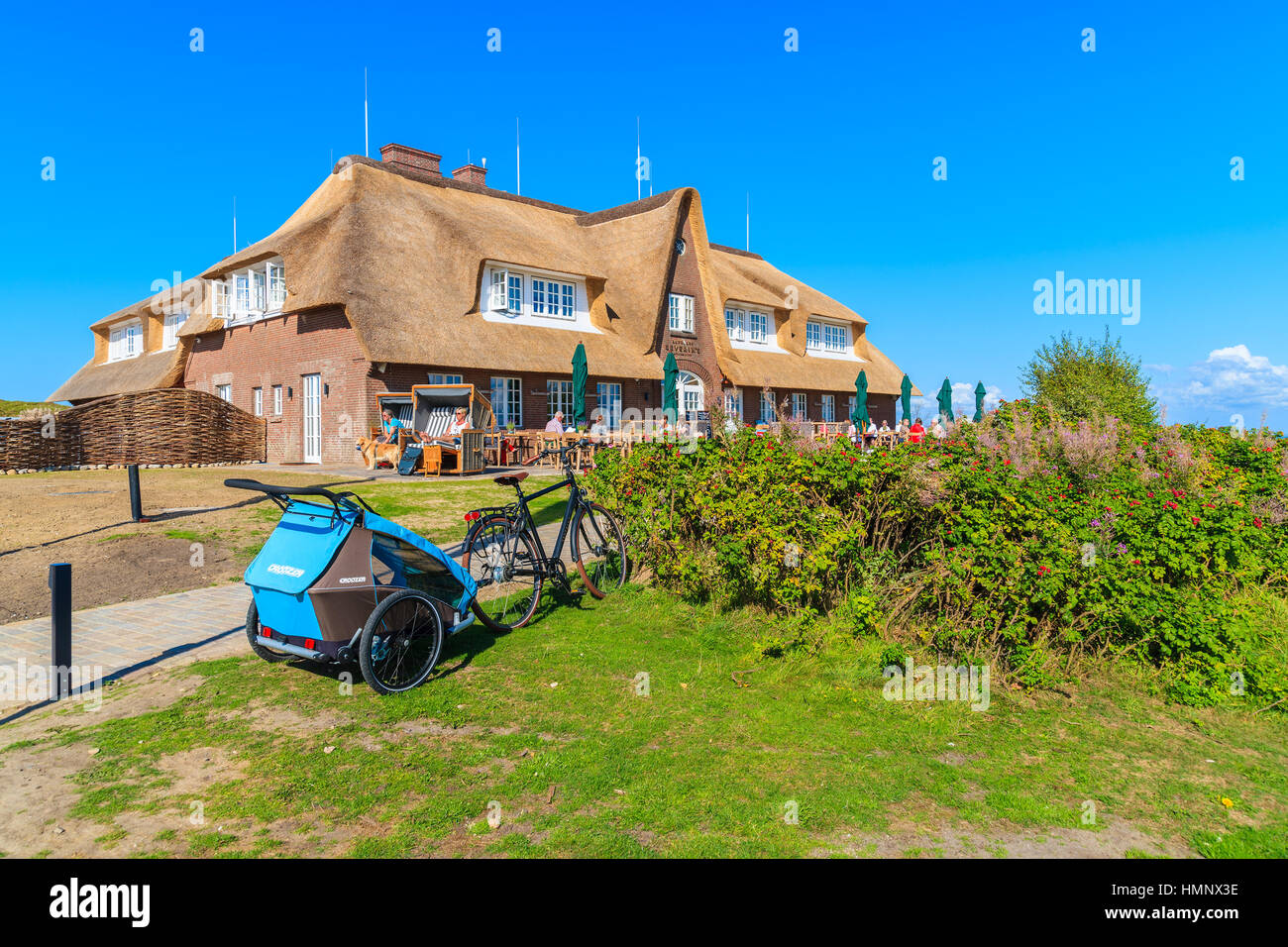 L'île de Sylt, ALLEMAGNE - SEP 9, 2016 : vélo avec remorque enfant garées en face de bâtiment restaurant près de Monsur falaise, l'île de Sylt, Allemagne. Banque D'Images