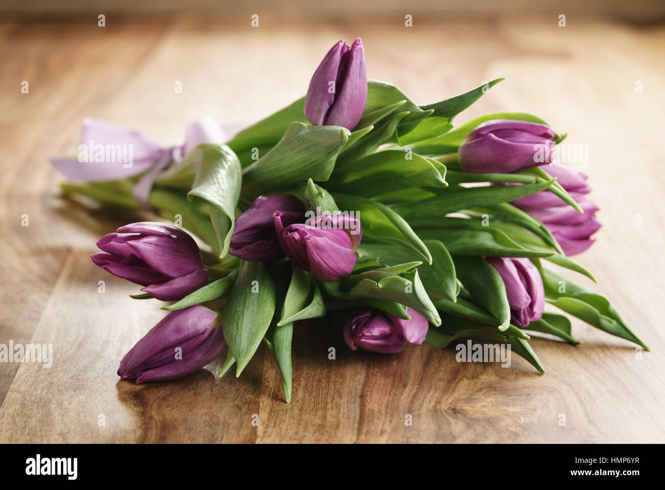 Bouquet de tulipes violettes sur table en bois Banque D'Images