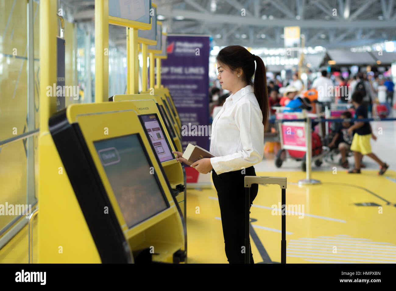 Young Asian businesswoman en utilisant les bornes d'enregistrement à l'aéroport. La technologie dans l'aéroport. Banque D'Images