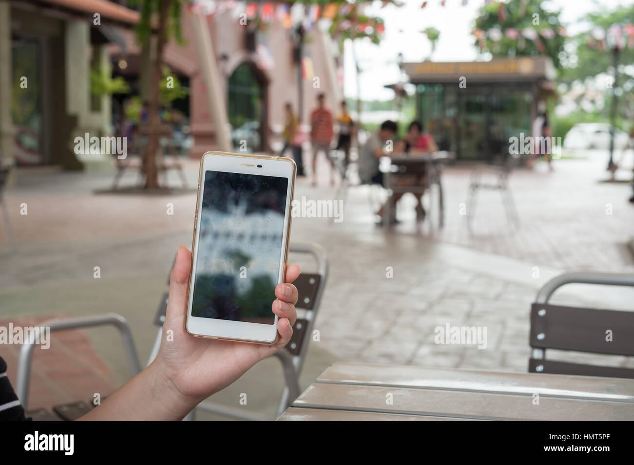 Femme main gauche montrant l'écran du téléphone mobile au coffee shop. Week-end avec le mode de vie urbain technologie concept Banque D'Images
