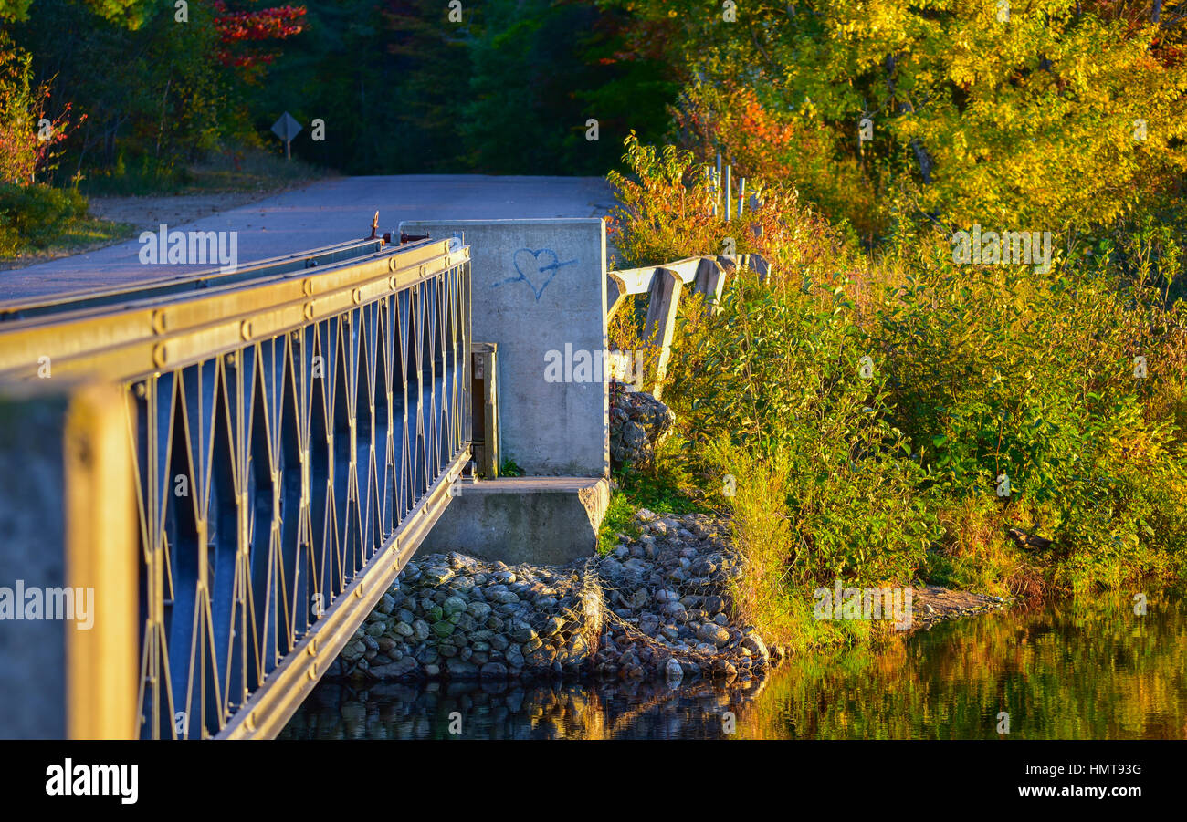 Amour perdu - une flèche au moyen d'un blue valentine, peints sur une culée de pont, golden sun l'été brille sur le pont d'acier léger au-dessus d'un lac. Banque D'Images