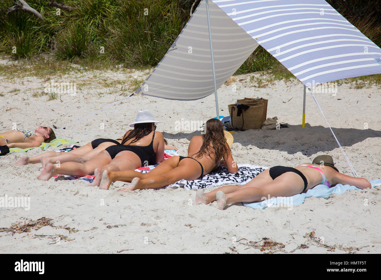 Quatre jeunes filles bikinis se détendent et bronzer sur la plage  australienne en été Photo Stock - Alamy
