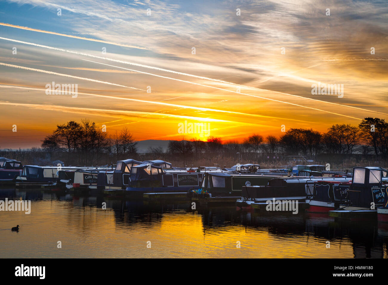 Rufford, Lancashire, Royaume-Uni. Feb 6, 2017. Météo britannique. Le froid glacial et brumeuse début mais lumineux et ensoleillé. Une partie merveilleuse de Lancashire rural sur la branche de l'Rufford Leeds et Liverpool Canal. avec des avions qui sillonnent le ciel en route pour l'aéroport de Manchester. Une traînée de forme derrière un jet si, comme gaz d'échappement refroidissent et mélanger avec l'air ambiant, l'humidité est suffisamment élevée et la température suffisamment basse pour que l'eau liquide de se condenser. L'air doit être saturée, et généralement la température inférieure à -40°F. Credit : MediaWorldImages/Alamy Live News Banque D'Images