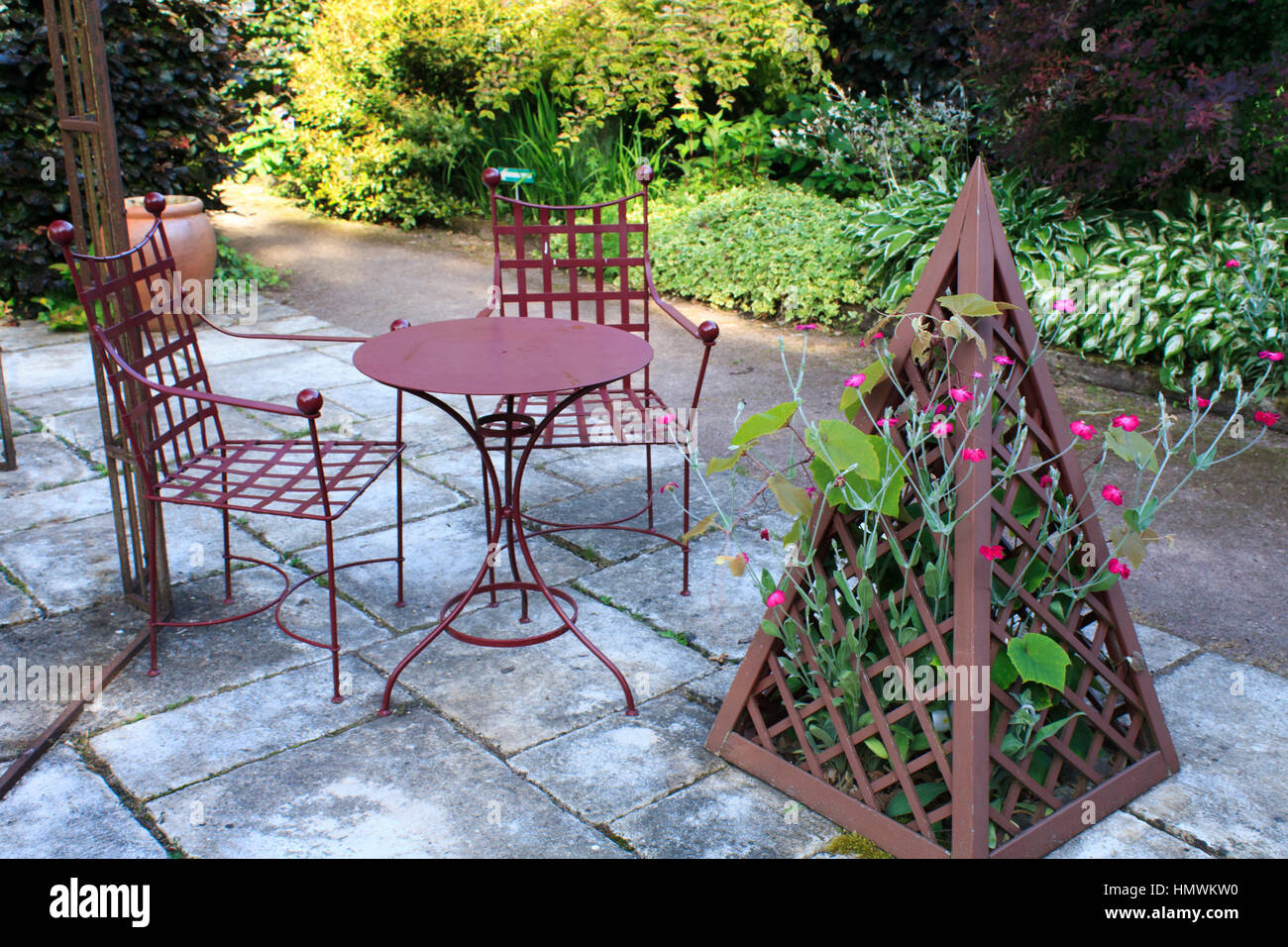 Jardins du pays d'Auge (mention obligatoire dans la légende ou le crédit photo) :'le jardin pourpre', terrasse dallée avec mobilier en fer et pyramide Banque D'Images