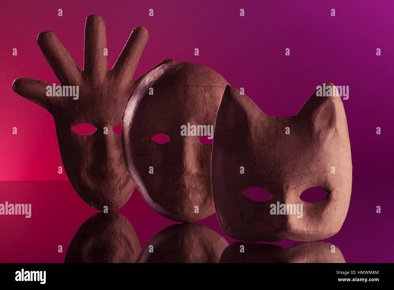 Trois masques en papier mâché sur une surface réfléchissante. Maintenue en place avec blu tack et beaucoup de patience ! Strobist : Yongnuo 560III avec un aGridded softbox Banque D'Images